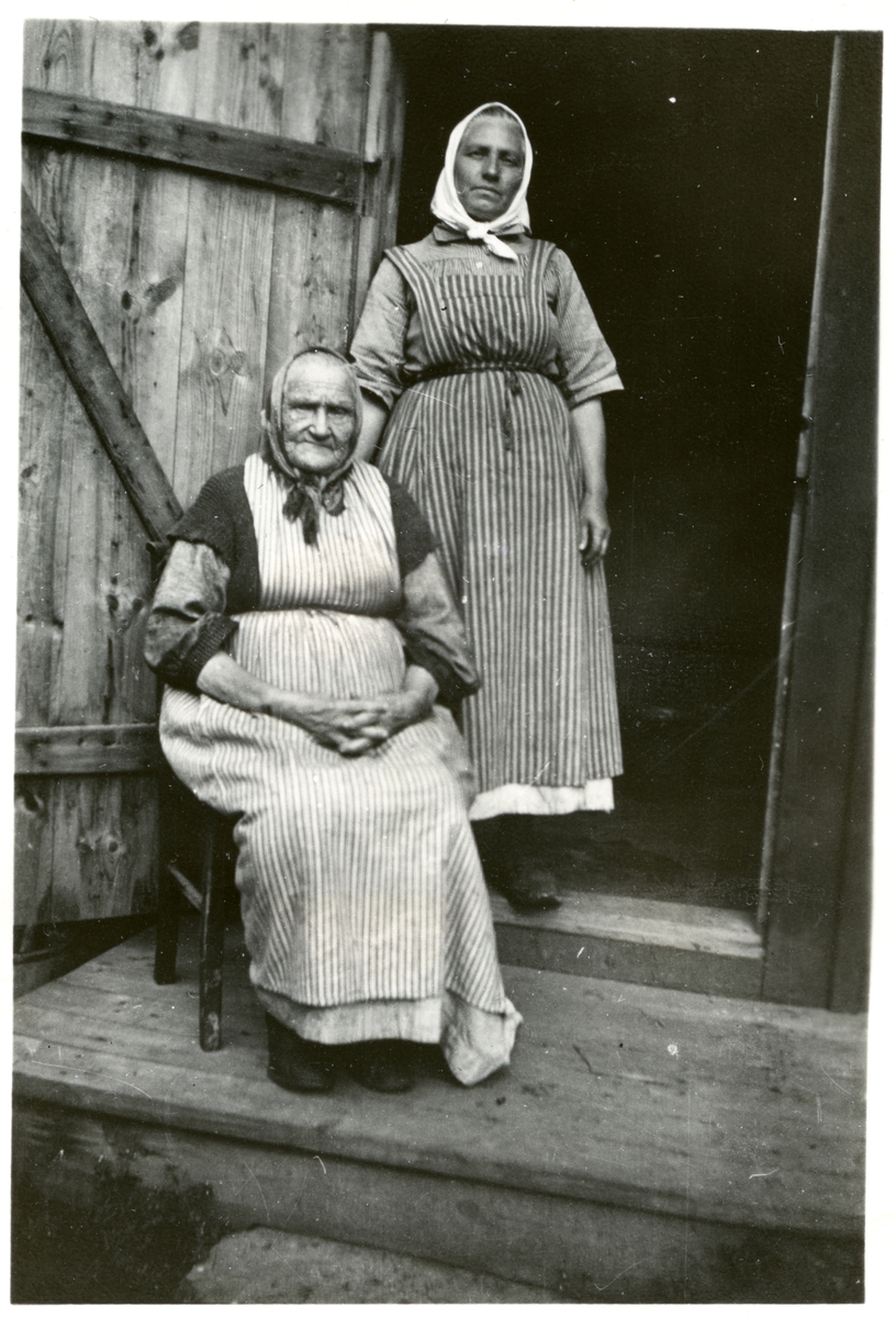 Dingtuna sn, Västerås.
Stockkumla gård. Två kvinnor med randiga förkläden och "hucklen". 1898-1910.