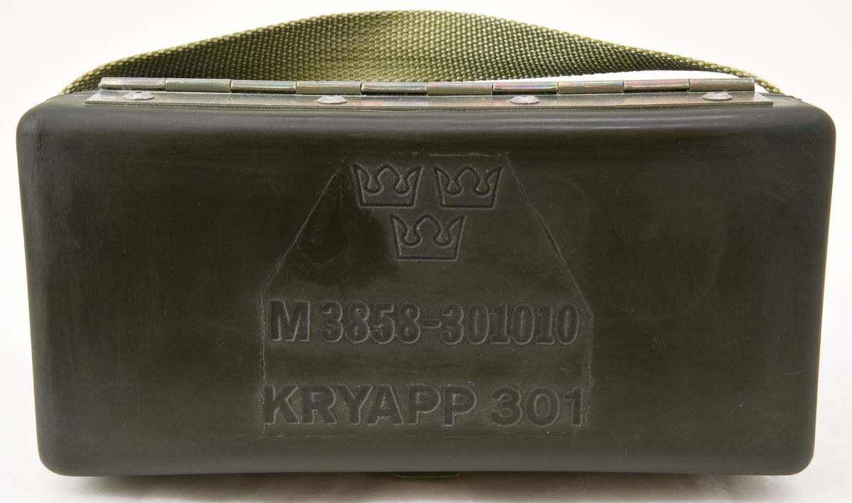 Krypteringsapparat (:1) med hölje av grönmålat aluminium i rundade former. Översidans framkant är lätt fasad och har ett avlångt fönster med alfabetet i över- och nederkant. Fönstret är till för att visa den alfabetsrulle som gav lösningen på kryptot. Under fönstret finns en svart skylt med vit text där siffrors bokstavskoder visas. På ovansidans mitt finns fem smala chifferhjul av svart bakelit i en försänkning. Hjulen är till för att ställa in chiffrets bokstäver som syns i ett fönster längst upp på apparatens ovansida. Till höger om chifferfönstret finns ett räkneverk med fyra siffror.

På apparatens framkant finns en skylt med M-nummer, serienummer och liknande och till höger ett vred av svart bakelit för att mata fram alfabetsrullen. På apparatens vänstra sida finns ett frammatningsvred av metall samt tillverkarens logotyp. På den högra sidan finns en lucka för alfabetsrullen och ett vred av bakelit för att ställa in chifferhjulaxeln. Baksidan har en större lucka för hålkortsplatsen och undersidan har små gummifötter samt en dekal med information om garantitid.

Till apparaten hör också en transportväska (:2) av formgjuten och genomfärgad gummi. Väskan är grön och har en vävd bärrem fäst med mässingsskruv. Locket är fäst med ett avlångt, nitat gångjärn och har ett låsspänne i mässing. På locket finns tre kronor och apparatens M-nummer i relief och på väskans undersida finns väskans M-nummer. Insidan av väskan är formad efter kryptoapparaten för att ge så mycket skydd som möjligt.

M-nummer: M 3858-301010
Tillverkningsnummer: 22749

Väskans M-nummer: M 7038-045010