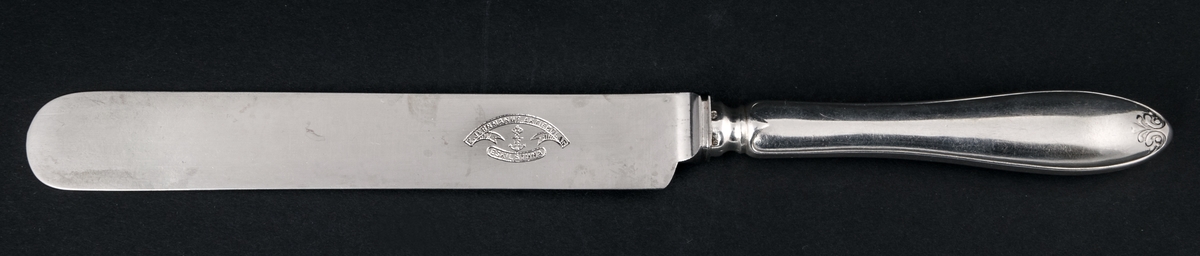 36 stycken matknivar av silver. Linjeartat ornament på skaftet. Gammelfransk modell.
Stämplad: GM D7 Kontrollstämpel, Sthlm.
Knivbladet: E. Jernmanuf. Aktiebolag, Eskilstuna.
Monogram: PE