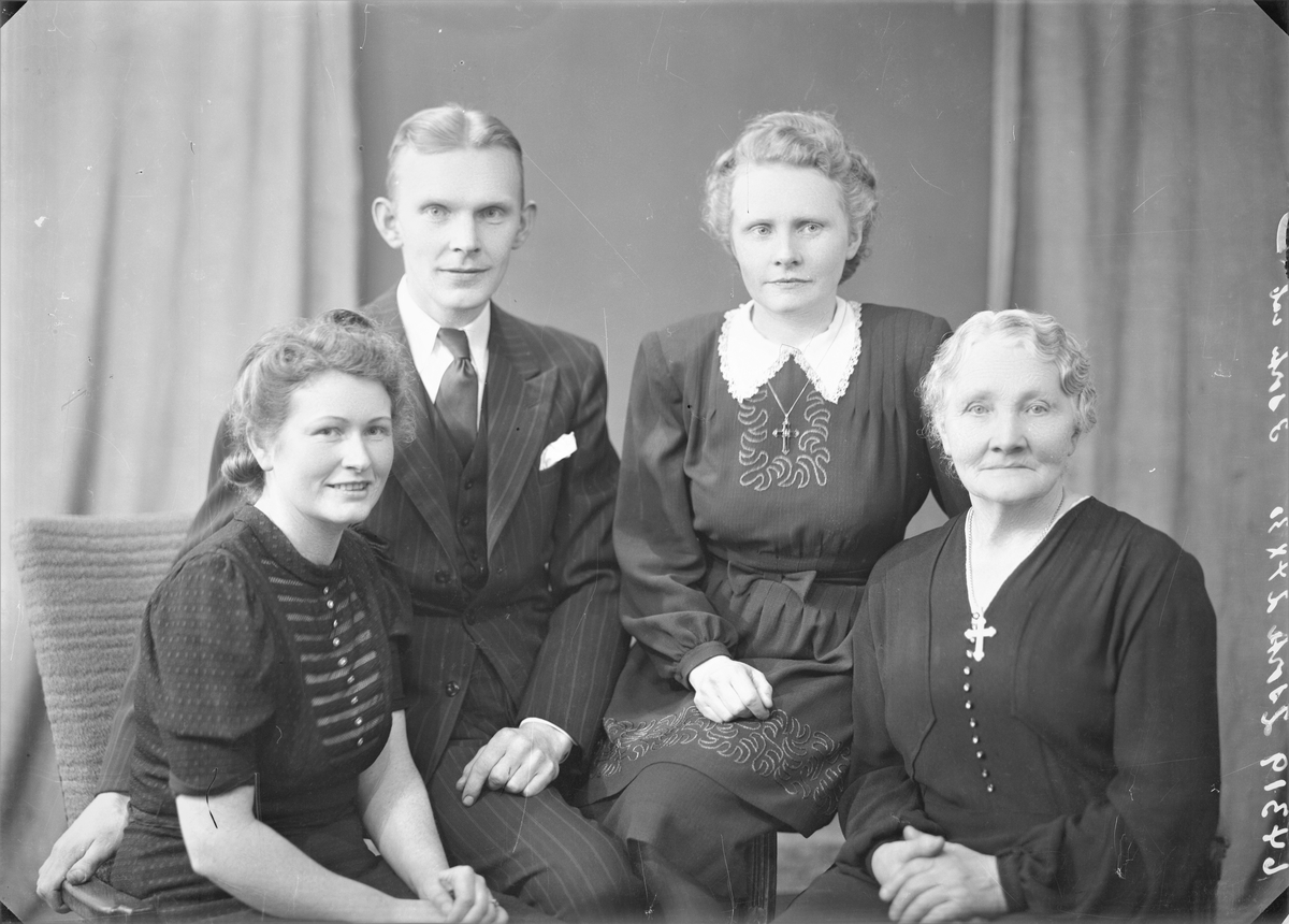 Portrett. To foto med lyshåret eldre kvinne i mørk kjole med perleknapper i front. Kors om halsen. Gruppebilde. Familiegruppe på fire. Fire foto med ung lyshåret mann i mørk stripet dress, mørk vest, hvit skjorte og mørkt slips, ung mørkblond kvinne i mørk mønstret kjole med hvite striper og hvite knapper i front, ung mørkblond kvinne i mørk kjole med broderinger i front og hvt krage. Lyshåret eldre kvinne i mørk kjole med perleknapper i front. Kors om halsen. Bestilt av Fru Serine Dybdal Henriksen.
