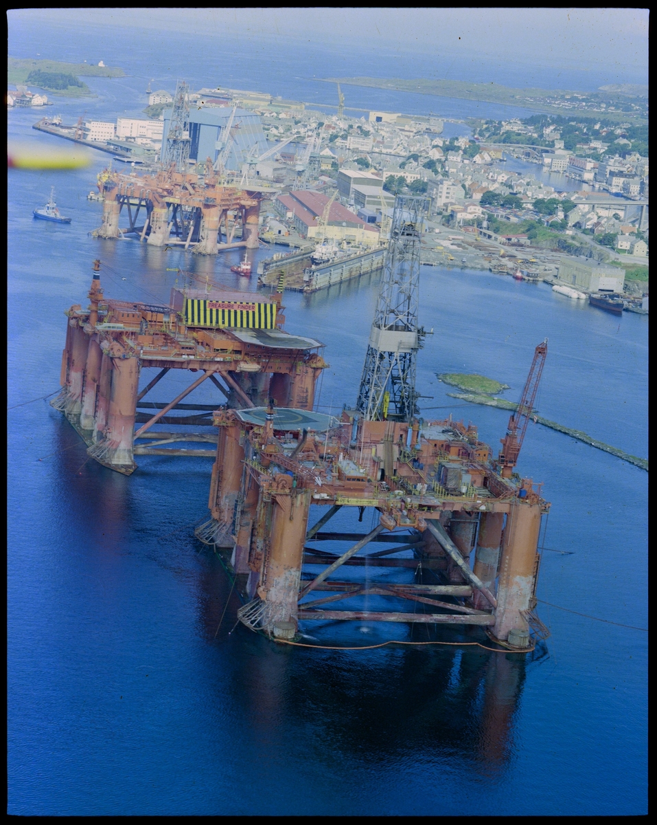 Ulike flyfoto av Haugesund Mekaniske Verksted med skip i dokk og oppankrede rigger.