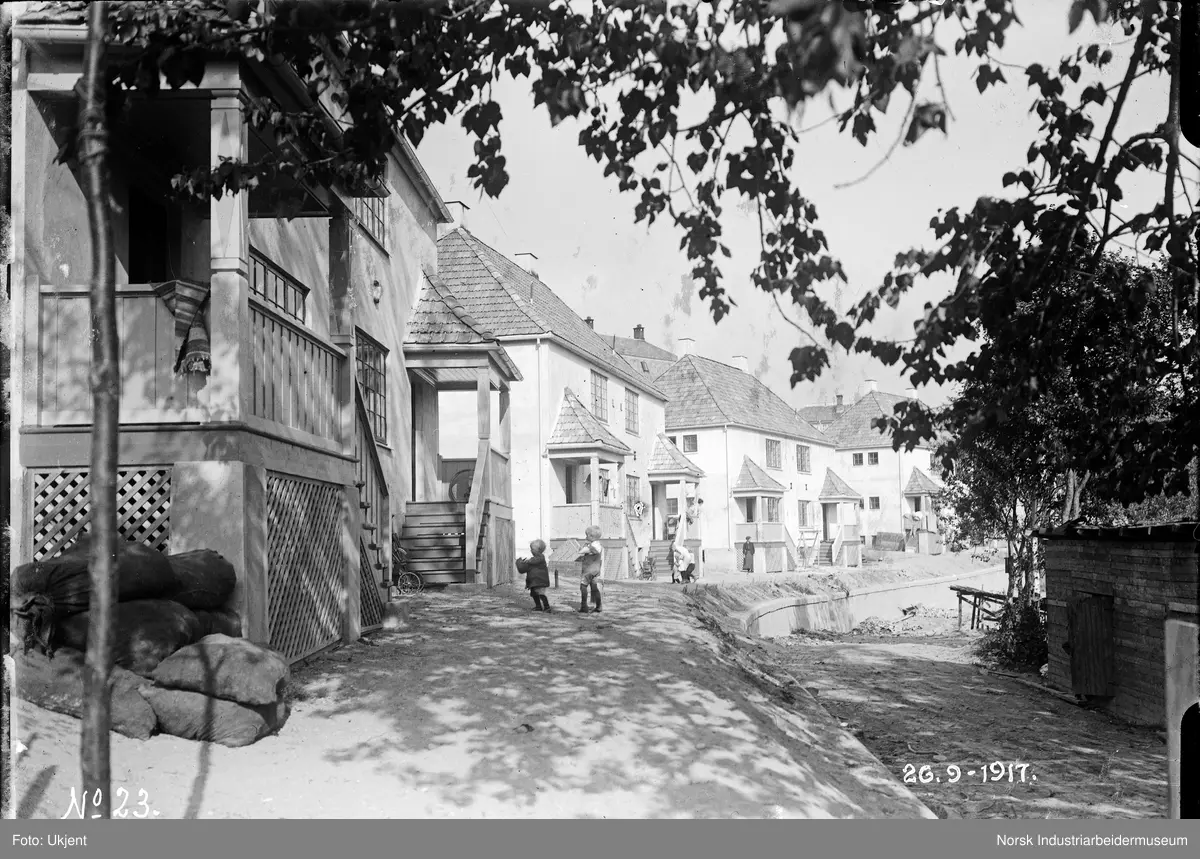 Femrader'n. Barn leker foran hus.