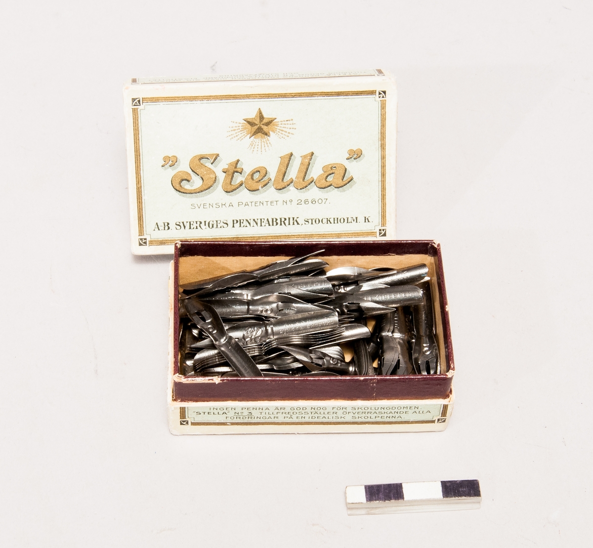 82 st. "Stella" pennor i sin orginalask från Sveriges pennfabrik samt två med patent taget av kongl. hofkalligraf J. Andersson. "Stellas" patent nr. är No.26607.
Tillbehör: Ask.