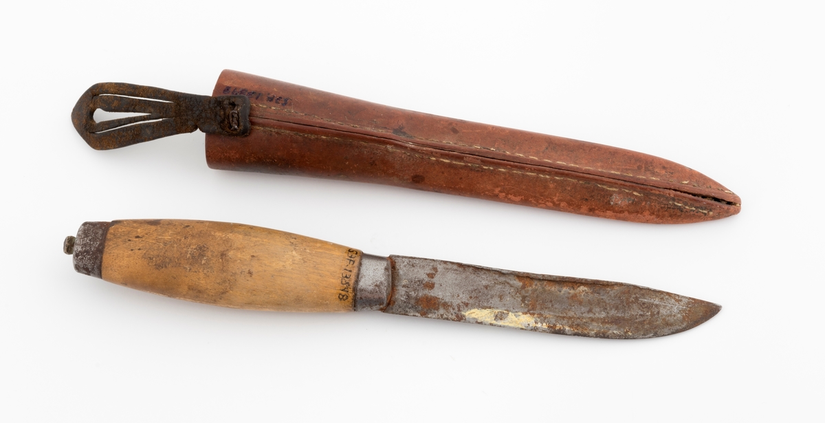 Tollekniv med slire, produsert av B. Knudsen på Ila i Trondheim. Kniven er 22,3 centimeter lang fra spissen av bladet til knappen i den bakre enden av skaftet. Bladet er 11,1 centimeter langt og snaut 2,1 centimeter bredt ved brystningen innerst mot skaftet. Bladet var opprinnelig snaut 3 millimeter tjukt, men bladryggen har slagmerker som har gjort den noe bredere. Sannsynligvis har dette skjedd fordi eieren har slått på knivnakken med et slagredskap for å kunne kløyve stikker som skulle brukes under opptenning. Den venstre sida av knivbladet bære smedstempelet «B. KNUDSEN  ILEN  TRONDHJEM». 

Kniven har et 10,8 centimeter langt treskaft med cirka 1 centimeter brede holker i begge ender. I den bakre enden er det en cirka 5 millimeter høy knopp med skråslipt endeflate. Treskaftet har en konveks form og et ovalt tverrsnitt. Midtpartiet måler 2,9 X 2,2 centimeter. Skaftet er ikke innsatt med noe fargestoff, men det kan ha vært oljet.

Slira er 18,2 centimeter lang, men har i tillegg en lærstropp for feste i en knapp i bukselinninga, slik at total lengde blir 24,6 centimeter. Sliras hoveddel er lagd av brunlig papp og holdes sammen av en søm langs det som var midtaksen av sliras bakside. Forsida av den delen av slira som omgav knivbladet har et siksak-mønster med litt skravur.

Knivmakerne Broder Knudsen (1886-1967) og Bård Knudsen bodde i Trondheim. Det er sannsynlig at en av disse har produsert denne kniven.