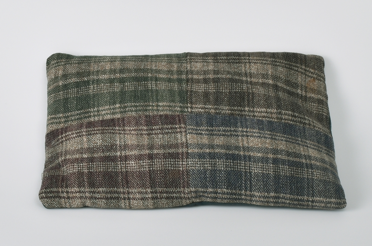 Pute; forsiden er sydd sammen av fire vevde felt.  Ullstoff på baksiden.