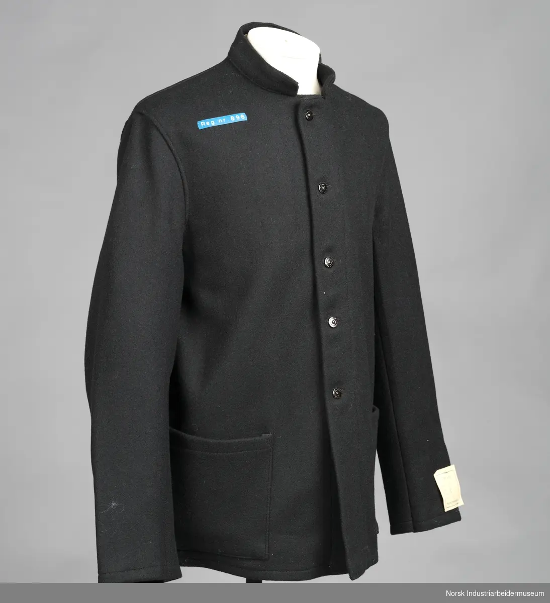 Sort arbeidsdress (jakke og bukse) med sorte blanke knapper.