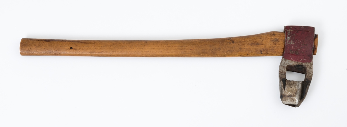 Øks - brukt til merking av fløtingstømmer i målings- og annammingsprosessen som foregikk langs vassdragene i overgangsfasen mellom vinter og vår, da tømmerstokkene etter måling formelt skiftet eier - fra skogeieren som hadde organisert hogst og framkjøring til sagbruk eller treforedlingsbedrift, som kjøpte tømmeret med sikte på videre bearbeiding til produkter som var salgbare på et større marked. 

Øksehodet (den smidde delen) er 16,3 centimeter høyt fra eggpartiet til nakken. Nakkedelen er 6,0 centimeter lang og om lag 2,6 centimeter bred. «Kjakene» - sideveggene rundt «øyet» (skafthullet) – er forholdsvis rette. På den nedre delen av øksebladet er det en U-formet utsparing, og til endestavene (Knudsen-smedene kalte dem «stabler») er det påsveiset en cirka 4,6 centimeter høy fasslipt, profilegget «sko». Eggprofilen er en trekant med en halvsirkelformet utbuktning på ei av sideflatene. Dette symbolet ble altså slått inn i yteveden på fløtingstømmeret, som tegn på hvem som eide stokkene. Den øvre delen av øksehodet er lakkert med rød lakk. På venstre side av dette øksebladet (sett i øksebrukerens perspektiv) finner vi smedstempelet «K. KNUDSEN  PATENT  MJØNDALEN». Smeden Karl Henrik Knudsen (1870-1956) tok patent på denne typen merkeøkser i 1908.

Øksa har et 60 centimeter langt og forholdsvis rett treskaft (sannsynligvis ask eller hickory). Som økseskaft flest er det bredest i høyderetningen og smalest i bredderetningen i den fremre enden, og mer rundovalt bakerst. Den fremre enden av skaftet er kilet med en trekile som skulle redusere faren for at øksa løsnet fra skaftet under merkingsarbeidet. Den venstre skaftsida har vært påført et navn ved hjelp av et svijernstempel.  Navnet er imidlertid forsøkt fjernet ved hjelp av ei rasp, antakelig fordi det firmaet som opprinnelig fikk tømmeret sitt merket med denne øksa ble avviklet, slik at merket muligens ble overtatt av en annen virksomhet. Det kan se ut til å ha stått «GL. KUR KOMPANI».

Litt generell informasjon om bruken av merkeøkser i skogbruket finnes under fanen «Opplysninger».