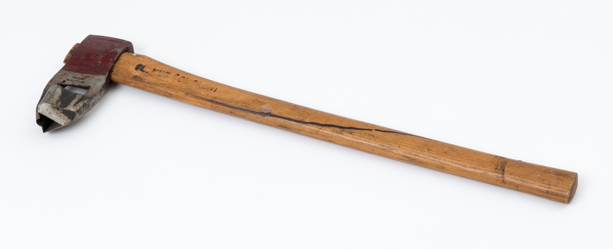 Øks - brukt til merking av fløtingstømmer i målings- og annammingsprosessen som foregikk langs vassdragene i overgangsfasen mellom vinter og vår, da tømmerstokkene etter måling formelt skiftet eier - fra skogeieren som hadde organisert hogst og framkjøring til sagbruk eller treforedlingsbedrift, som kjøpte tømmeret med sikte på videre bearbeiding til produkter som var salgbare på et større marked. 

Øksehodet (den smidde delen) er 16,3 centimeter høyt fra eggpartiet til nakken. Nakkedelen er 6,0 centimeter lang og om lag 2,6 centimeter bred. «Kjakene» - sideveggene rundt «øyet» (skafthullet) – er forholdsvis rette. På den nedre delen av øksebladet er det en U-formet utsparing, og til endestavene (Knudsen-smedene kalte dem «stabler») er det påsveiset en cirka 4,6 centimeter høy fasslipt, profilegget «sko». Eggprofilen er en trekant med en halvsirkelformet utbuktning på ei av sideflatene. Dette symbolet ble altså slått inn i yteveden på fløtingstømmeret, som tegn på hvem som eide stokkene. Den øvre delen av øksehodet er lakkert med rød lakk. På venstre side av dette øksebladet (sett i øksebrukerens perspektiv) finner vi smedstempelet «K. KNUDSEN  PATENT  MJØNDALEN». Smeden Karl Henrik Knudsen (1870-1956) tok patent på denne typen merkeøkser i 1908.

Øksa har et 60 centimeter langt og forholdsvis rett treskaft (sannsynligvis ask eller hickory). Som økseskaft flest er det bredest i høyderetningen og smalest i bredderetningen i den fremre enden, og mer rundovalt bakerst. Den fremre enden av skaftet er kilet med en trekile som skulle redusere faren for at øksa løsnet fra skaftet under merkingsarbeidet. Den venstre skaftsida har vært påført et navn ved hjelp av et svijernstempel.  Navnet er imidlertid forsøkt fjernet ved hjelp av ei rasp, antakelig fordi det firmaet som opprinnelig fikk tømmeret sitt merket med denne øksa ble avviklet, slik at merket muligens ble overtatt av en annen virksomhet. Det kan se ut til å ha stått «GL. KUR KOMPANI».

Litt generell informasjon om bruken av merkeøkser i skogbruket finnes under fanen «Opplysninger».