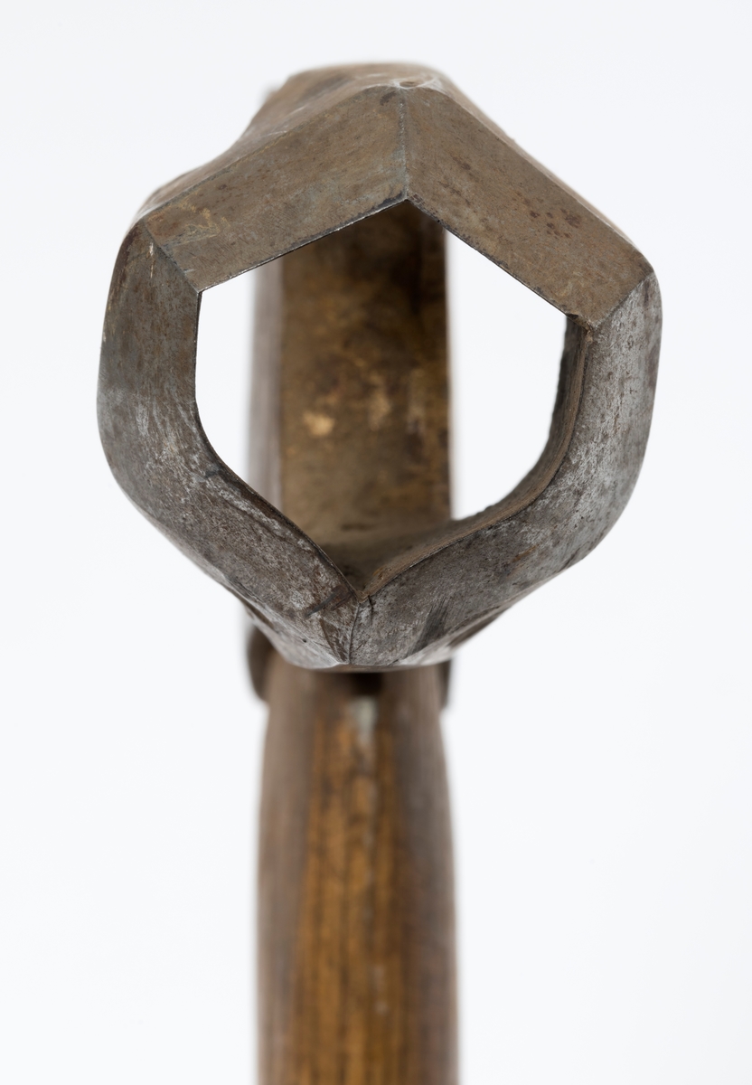 Øks - brukt til merking av fløtingstømmer i målings- og annammingsprosessen som foregikk langs vassdragene i overgangsfasen mellom vinter og vår, da tømmerstokkene etter måling formelt skiftet eier - fra skogeieren som hadde organisert hogst og framkjøring til sagbruk eller treforedlingsbedrift, som kjøpte tømmeret med sikte på videre bearbeiding til produkter som var salgbare på et større marked. 

Øksehodet (den smidde delen) er 13,5 centimeter høyt fra eggpartiet til nakken. Nakkedelen er 7,9 centimeter lang og om lag 2,6 centimeter bred bakerst, 2,2 centimeter i fronten. «Kjakene» - sideveggene rundt «øyet» (skafthullet) – smalner fra nakkepartiet mot den nedre delen av bladet. På den nedre delen av øksebladet er det en U-formet utsparing, og til endestavene (Knudsen-smedene kalte dem «stabler») er det påsveiset en cirka 3,7 centimeter høy fasslipt, profilegget «sko». Eggprofilen ble altså slått inn i yteveden på fløtingstømmeret, som tegn på hvem som eide stokkene. Øksehodet er, med unntak av den fasslipte eggen, lakkert med gulfarget lakk. Øverst på høyre side av øksehodet (sett i øksebrukerens perspektiv) finner vi stempelet «K. KNUDSEN MJØNDALEN» sammen med avbildninger av to medaljer denne smeden hadde oppnådd under vareutstillinger der han hadde vist produktene sine. Karl Henrik Knudsen (1870-1956) i Mjøndalen i Nedre Eiker patenterte denne typen merkeøkser i 1908.

Denne øksa har et drøyt 60,5 centimeter langt og forholdsvis rett treskaft (sannsynligvis ask eller hickory). Som økseskaft flest er det bredest i høyderetningen og smalest i bredderetningen i den fremre enden, og mer rundovalt bakerst. Den fremre enden av skaftet er kilet med en trekile som skulle redusere faren for at øksa løsnet fra skaftet under merkingsarbeidet.

Merkekart for Glomma knytter denne øksa til tømmer som ble annammet på vegne av firmaet Bay & Torp (merke nr. 223)

Litt generell informasjon om bruken av merkeøkser i skogbruket finnes under fanen «Opplysninger».