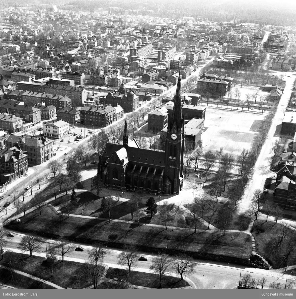 Flygfoto över Sundsvall söderut med kyrkan i centrum och bakom den Läroverket och GA-skolan. I vänsterkant Skolhusallén, nedtill Storgatan.