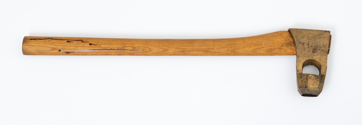 Øks - brukt til merking av fløtingstømmer i målings- og annammingsprosessen som foregikk langs vassdragene i overgangsfasen mellom vinter og vår, da tømmerstokkene etter måling formelt skiftet eier - fra skogeieren som hadde organisert hogst og framkjøring til sagbruk eller treforedlingsbedrift, som kjøpte tømmeret med sikte på videre bearbeiding til produkter som var salgbare på et større marked. 

Øksehodet (den smidde delen) er 13,1 centimeter høyt fra eggpartiet til nakken. Nakkedelen er 8,2 centimeter lang og om lag 2,5 centimeter bred bakerst, 2,2 centimeter i fronten. «Kjakene» - sideveggene rundt «øyet» (skafthullet) – smalner fra nakkepartiet mot den nedre delen av bladet. På den nedre delen av øksebladet er det en U-formet utsparing, og til endestavene (Knudsen-smedene kalte dem «stabler») er det påsveiset en cirka 3,8 centimeter høy fasslipt, profilegget «sko». Eggprofilen er en noe avlang åttekant (oktogon). Dette symbolet ble altså slått inn i yteveden på fløtingstømmeret, som tegn på hvem som eide stokkene. Øksehodet er, med unntak av den fasslipte eggen, lakkert med gulfarget lakk. Denne øksa har ikke noe smedstempel, men form og overflatebehandling tyder på at den er produsert av smeden Karl Henrik Knudsen (1870-1956) i Mjøndalen i Nedre Eiker.

Denne øksa har et 61 centimeter langt og forholdsvis rett treskaft (sannsynligvis ask eller hickory). Som økseskaft flest er det bredest i høyderetningen og smalest i bredderetningen i den fremre enden, og mer rundovalt bakerst. Den fremre enden av skaftet er kilet med en trekile som skulle redusere faren for at øksa løsnet fra skaftet under merkingsarbeidet.

Ifølge «Merkekart 1953 for Glommen» (gjengitt i Julius Nygaards skogalmanakk for 1954) ble dette merket brukt av Fetsund lenser i Glommavassdraget (jfr. merke nr. 35).

Litt generell informasjon om bruken av merkeøkser i skogbruket finnes under fanen «Opplysninger».