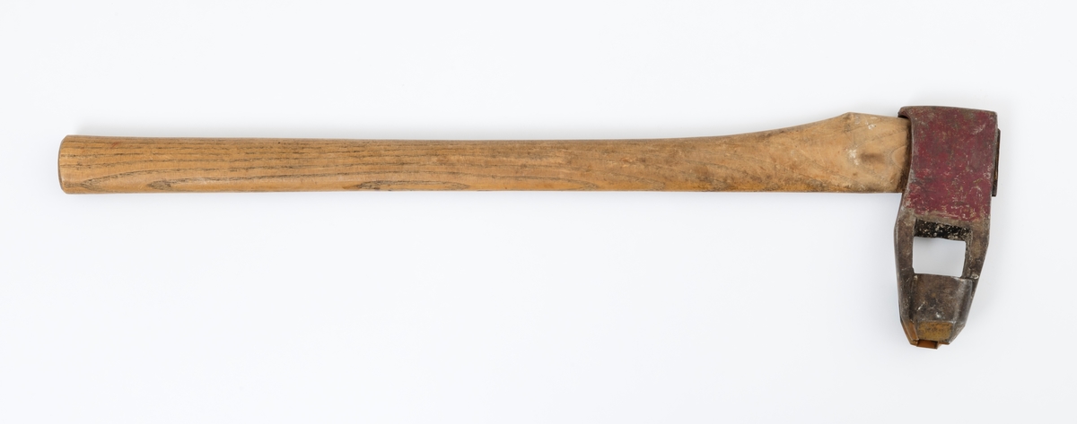 Øks – brukt til merking av fløtingstømmer i målings- og annammingsprosessen som foregikk langs vassdragene i overgangsfasen mellom vinter og vår, da tømmerstokkene etter måling formelt skiftet eier – fra skogeieren som hadde organisert hogst og framkjøring til sagbruk eller treforedlingsbedrift, som kjøpte tømmeret med sikte på videre bearbeiding til produkter som var salgbare på et større marked. 

Øksehodet (den smidde delen) er cirka 15,5 centimeter høyt fra eggpartiet til nakken. Nakkedelen er 6,4 centimeter lang og om lag 2,2 centimeter bred. «Kjakene» – sideveggene rundt «øyet» (skafthullet) – er forholdsvis rette. På den nedre delen av øksebladet er det en U-formet utsparing, og til endestavene (Knudsen-smedene kalte dem «stabler») er det påsveiset en cirka 4 centimeter høy fasslipt, profilegget «sko». Eggprofilen er formet som omrisset av et stilisert damplokomotiv. Dette symbolet ble altså slått inn i yteveden på fløtingstømmeret, som tegn på hvem som eide stokkene. Den øvre delen av øksehodet er lakkert med rød lakk. På venstre side av dette øksebladet (sett i øksebrukerens perspektiv) finner vi smedstempelet «K. KNUDSEN  PATENT». Smeden Karl Henrik Knudsen (1870-1956) tok patent på denne typen merkeøkser i 1908.

Øksa har et 61 centimeter langt og forholdsvis rett treskaft (sannsynligvis ask eller hickory) som er overflatebehandlet med rasp. Som økseskaft flest er det bredest i høyderetningen og smalest i bredderetningen i den fremre enden, og mer rundovalt bakerst. Den fremre enden av skaftet er kilet med en jernkile som skulle redusere faren for at øksa løsnet fra skaftet under merkingsarbeidet.

Ifølge «Merkekart 1953 for Glommen» (gjengitt i Julius Nygaards skogalmanakk for 1954) ble dette merket brukt av Norges Statsbaner (jfr. merke nr. 35). På merkekartet fra 1920 er det samme merket knyttet til firmaet Melsom & Holth.

Litt generell informasjon om bruken av merkeøkser i skogbruket finnes under fanen «Opplysninger».