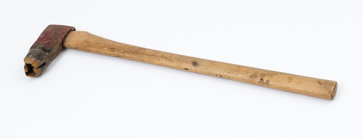 Øks – brukt til merking av fløtingstømmer i målings- og annammingsprosessen som foregikk langs vassdragene i overgangsfasen mellom vinter og vår, da tømmerstokkene etter måling formelt skiftet eier – fra skogeieren som hadde organisert hogst og framkjøring til sagbruk eller treforedlingsbedrift, som kjøpte tømmeret med sikte på videre bearbeiding til produkter som var salgbare på et større marked. 

Øksehodet (den smidde delen) er cirka 15,5 centimeter høyt fra eggpartiet til nakken. Nakkedelen er 6,4 centimeter lang og om lag 2,2 centimeter bred. «Kjakene» – sideveggene rundt «øyet» (skafthullet) – er forholdsvis rette. På den nedre delen av øksebladet er det en U-formet utsparing, og til endestavene (Knudsen-smedene kalte dem «stabler») er det påsveiset en cirka 4 centimeter høy fasslipt, profilegget «sko». Eggprofilen er formet som omrisset av et stilisert damplokomotiv. Dette symbolet ble altså slått inn i yteveden på fløtingstømmeret, som tegn på hvem som eide stokkene. Den øvre delen av øksehodet er lakkert med rød lakk. På venstre side av dette øksebladet (sett i øksebrukerens perspektiv) finner vi smedstempelet «K. KNUDSEN  PATENT». Smeden Karl Henrik Knudsen (1870-1956) tok patent på denne typen merkeøkser i 1908.

Øksa har et 61 centimeter langt og forholdsvis rett treskaft (sannsynligvis ask eller hickory) som er overflatebehandlet med rasp. Som økseskaft flest er det bredest i høyderetningen og smalest i bredderetningen i den fremre enden, og mer rundovalt bakerst. Den fremre enden av skaftet er kilet med en jernkile som skulle redusere faren for at øksa løsnet fra skaftet under merkingsarbeidet.

Ifølge «Merkekart 1953 for Glommen» (gjengitt i Julius Nygaards skogalmanakk for 1954) ble dette merket brukt av Norges Statsbaner (jfr. merke nr. 35). På merkekartet fra 1920 er det samme merket knyttet til firmaet Melsom & Holth.

Litt generell informasjon om bruken av merkeøkser i skogbruket finnes under fanen «Opplysninger».