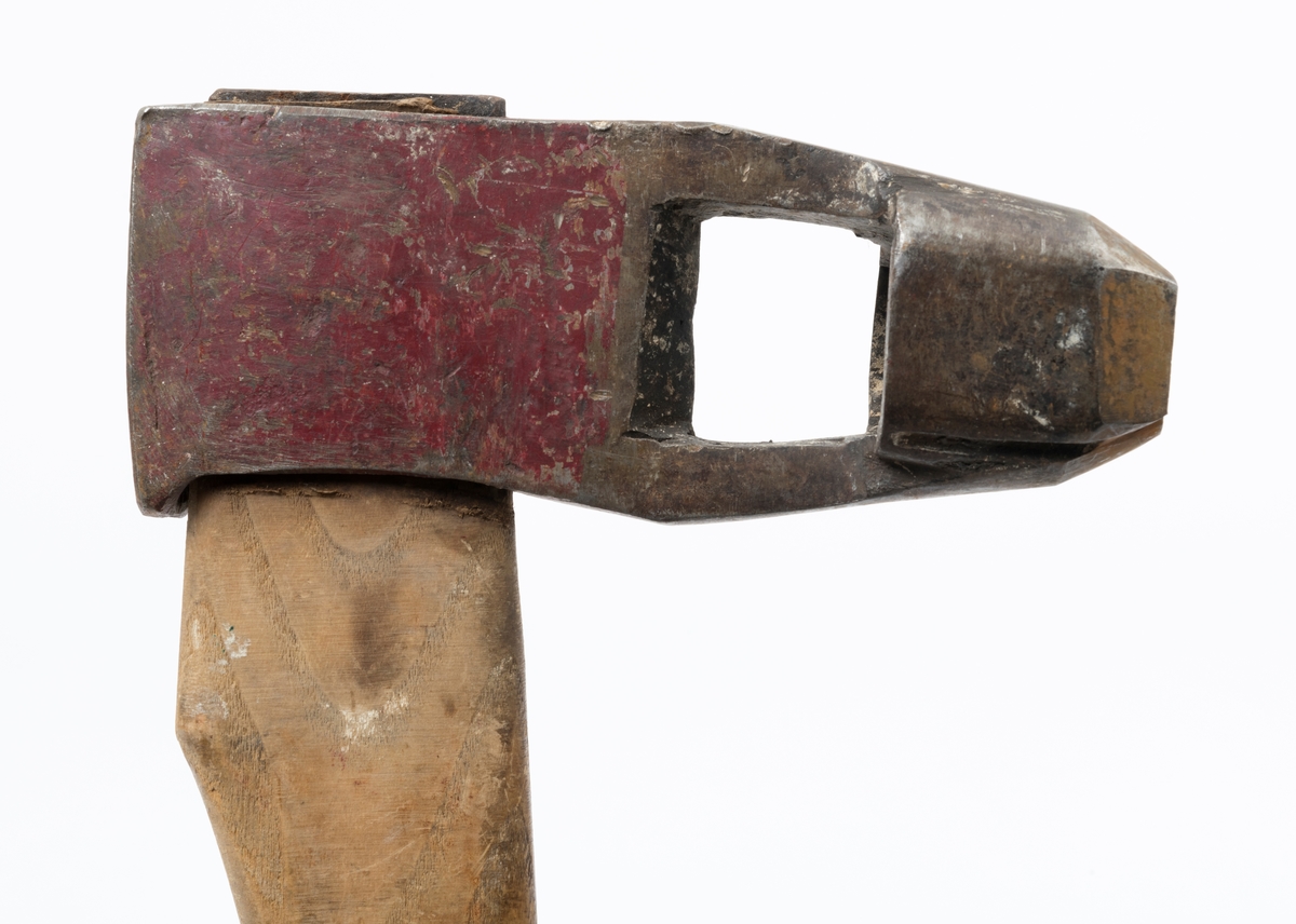 Øks – brukt til merking av fløtingstømmer i målings- og annammingsprosessen som foregikk langs vassdragene i overgangsfasen mellom vinter og vår, da tømmerstokkene etter måling formelt skiftet eier – fra skogeieren som hadde organisert hogst og framkjøring til sagbruk eller treforedlingsbedrift, som kjøpte tømmeret med sikte på videre bearbeiding til produkter som var salgbare på et større marked. 

Øksehodet (den smidde delen) er cirka 15,5 centimeter høyt fra eggpartiet til nakken. Nakkedelen er 6,4 centimeter lang og om lag 2,2 centimeter bred. «Kjakene» – sideveggene rundt «øyet» (skafthullet) – er forholdsvis rette. På den nedre delen av øksebladet er det en U-formet utsparing, og til endestavene (Knudsen-smedene kalte dem «stabler») er det påsveiset en cirka 4 centimeter høy fasslipt, profilegget «sko». Eggprofilen er formet som omrisset av et stilisert damplokomotiv. Dette symbolet ble altså slått inn i yteveden på fløtingstømmeret, som tegn på hvem som eide stokkene. Den øvre delen av øksehodet er lakkert med rød lakk. På venstre side av dette øksebladet (sett i øksebrukerens perspektiv) finner vi smedstempelet «K. KNUDSEN  PATENT». Smeden Karl Henrik Knudsen (1870-1956) tok patent på denne typen merkeøkser i 1908.

Øksa har et 61 centimeter langt og forholdsvis rett treskaft (sannsynligvis ask eller hickory) som er overflatebehandlet med rasp. Som økseskaft flest er det bredest i høyderetningen og smalest i bredderetningen i den fremre enden, og mer rundovalt bakerst. Den fremre enden av skaftet er kilet med en jernkile som skulle redusere faren for at øksa løsnet fra skaftet under merkingsarbeidet.

Ifølge «Merkekart 1953 for Glommen» (gjengitt i Julius Nygaards skogalmanakk for 1954) ble dette merket brukt av Norges Statsbaner (jfr. merke nr. 35). På merkekartet fra 1920 er det samme merket knyttet til firmaet Melsom & Holth.

Litt generell informasjon om bruken av merkeøkser i skogbruket finnes under fanen «Opplysninger».