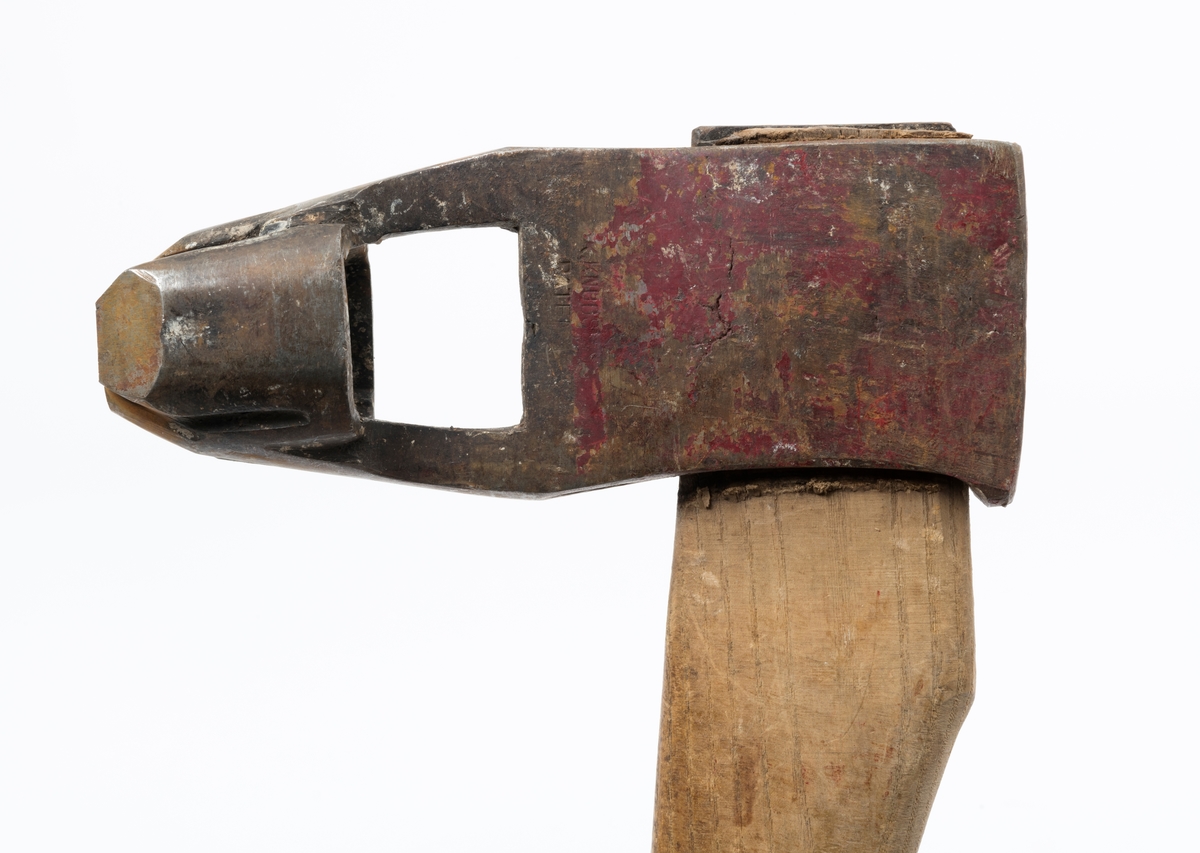 Øks – brukt til merking av fløtingstømmer i målings- og annammingsprosessen som foregikk langs vassdragene i overgangsfasen mellom vinter og vår, da tømmerstokkene etter måling formelt skiftet eier – fra skogeieren som hadde organisert hogst og framkjøring til sagbruk eller treforedlingsbedrift, som kjøpte tømmeret med sikte på videre bearbeiding til produkter som var salgbare på et større marked. 

Øksehodet (den smidde delen) er cirka 15,5 centimeter høyt fra eggpartiet til nakken. Nakkedelen er 6,4 centimeter lang og om lag 2,2 centimeter bred. «Kjakene» – sideveggene rundt «øyet» (skafthullet) – er forholdsvis rette. På den nedre delen av øksebladet er det en U-formet utsparing, og til endestavene (Knudsen-smedene kalte dem «stabler») er det påsveiset en cirka 4 centimeter høy fasslipt, profilegget «sko». Eggprofilen er formet som omrisset av et stilisert damplokomotiv. Dette symbolet ble altså slått inn i yteveden på fløtingstømmeret, som tegn på hvem som eide stokkene. Den øvre delen av øksehodet er lakkert med rød lakk. På venstre side av dette øksebladet (sett i øksebrukerens perspektiv) finner vi smedstempelet «K. KNUDSEN  PATENT». Smeden Karl Henrik Knudsen (1870-1956) tok patent på denne typen merkeøkser i 1908.

Øksa har et 61 centimeter langt og forholdsvis rett treskaft (sannsynligvis ask eller hickory) som er overflatebehandlet med rasp. Som økseskaft flest er det bredest i høyderetningen og smalest i bredderetningen i den fremre enden, og mer rundovalt bakerst. Den fremre enden av skaftet er kilet med en jernkile som skulle redusere faren for at øksa løsnet fra skaftet under merkingsarbeidet.

Ifølge «Merkekart 1953 for Glommen» (gjengitt i Julius Nygaards skogalmanakk for 1954) ble dette merket brukt av Norges Statsbaner (jfr. merke nr. 35). På merkekartet fra 1920 er det samme merket knyttet til firmaet Melsom & Holth.

Litt generell informasjon om bruken av merkeøkser i skogbruket finnes under fanen «Opplysninger».