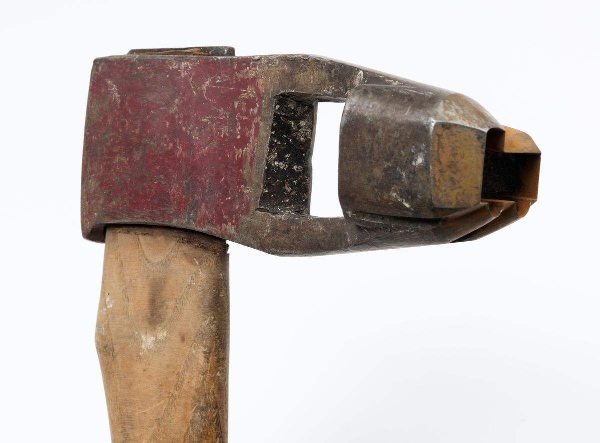 Øks – brukt til merking av fløtingstømmer i målings- og annammingsprosessen som foregikk langs vassdragene i overgangsfasen mellom vinter og vår, da tømmerstokkene etter måling formelt skiftet eier – fra skogeieren som hadde organisert hogst og framkjøring til sagbruk eller treforedlingsbedrift, som kjøpte tømmeret med sikte på videre bearbeiding til produkter som var salgbare på et større marked. 

Øksehodet (den smidde delen) er cirka 15,5 centimeter høyt fra eggpartiet til nakken. Nakkedelen er 6,4 centimeter lang og om lag 2,2 centimeter bred. «Kjakene» – sideveggene rundt «øyet» (skafthullet) – er forholdsvis rette. På den nedre delen av øksebladet er det en U-formet utsparing, og til endestavene (Knudsen-smedene kalte dem «stabler») er det påsveiset en cirka 4 centimeter høy fasslipt, profilegget «sko». Eggprofilen er formet som omrisset av et stilisert damplokomotiv. Dette symbolet ble altså slått inn i yteveden på fløtingstømmeret, som tegn på hvem som eide stokkene. Den øvre delen av øksehodet er lakkert med rød lakk. På venstre side av dette øksebladet (sett i øksebrukerens perspektiv) finner vi smedstempelet «K. KNUDSEN  PATENT». Smeden Karl Henrik Knudsen (1870-1956) tok patent på denne typen merkeøkser i 1908.

Øksa har et 61 centimeter langt og forholdsvis rett treskaft (sannsynligvis ask eller hickory) som er overflatebehandlet med rasp. Som økseskaft flest er det bredest i høyderetningen og smalest i bredderetningen i den fremre enden, og mer rundovalt bakerst. Den fremre enden av skaftet er kilet med en jernkile som skulle redusere faren for at øksa løsnet fra skaftet under merkingsarbeidet.

Ifølge «Merkekart 1953 for Glommen» (gjengitt i Julius Nygaards skogalmanakk for 1954) ble dette merket brukt av Norges Statsbaner (jfr. merke nr. 35). På merkekartet fra 1920 er det samme merket knyttet til firmaet Melsom & Holth.

Litt generell informasjon om bruken av merkeøkser i skogbruket finnes under fanen «Opplysninger».