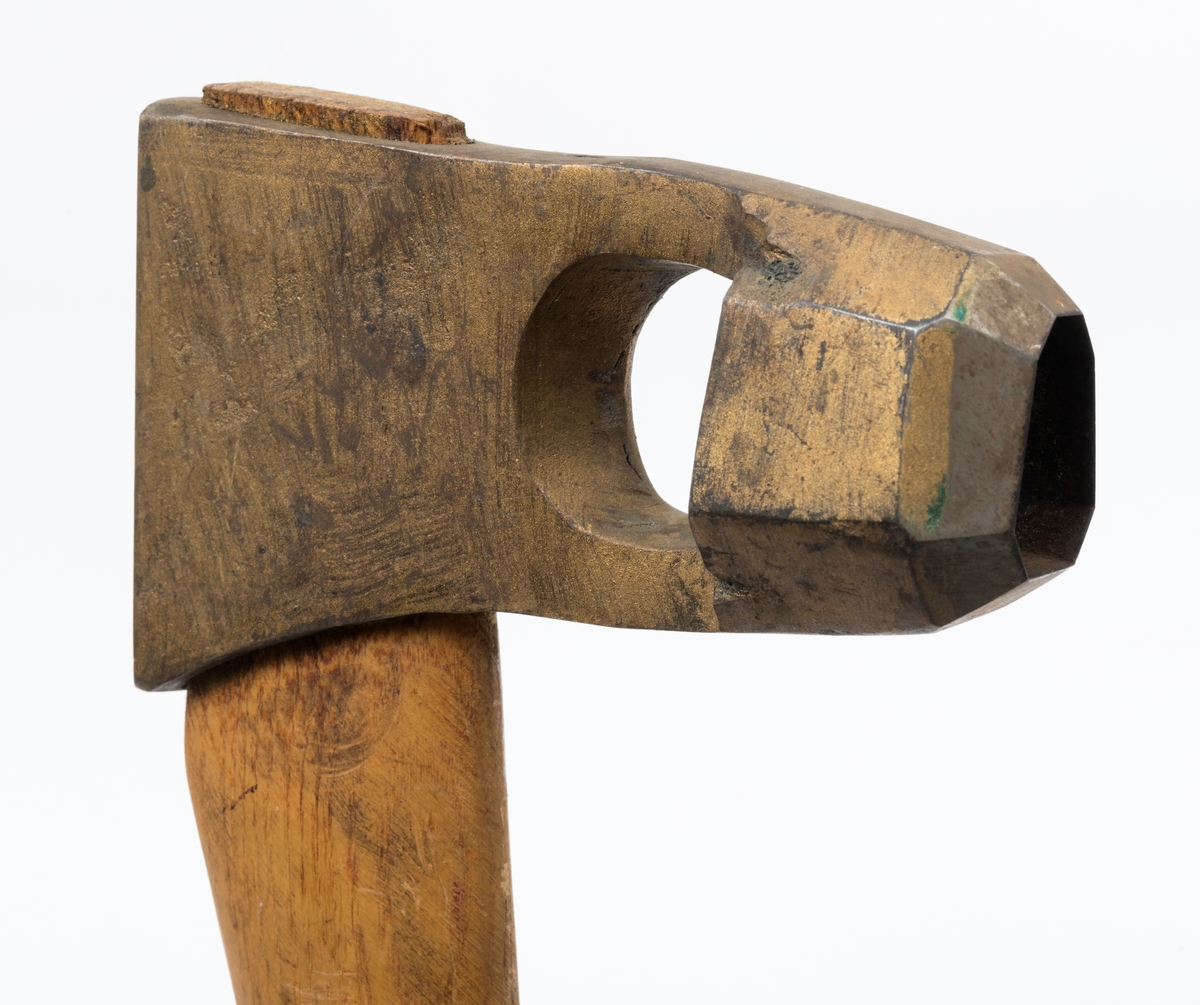 Øks - brukt til merking av fløtingstømmer i målings- og annammingsprosessen som foregikk langs vassdragene i overgangsfasen mellom vinter og vår, da tømmerstokkene etter måling formelt skiftet eier - fra skogeieren som hadde organisert hogst og framkjøring til sagbruk eller treforedlingsbedrift, som kjøpte tømmeret med sikte på videre bearbeiding til produkter som var salgbare på et større marked. 

Øksehodet (den smidde delen) er 13,1 centimeter høyt fra eggpartiet til nakken. Nakkedelen er 8,2 centimeter lang og om lag 2,5 centimeter bred bakerst, 2,2 centimeter i fronten. «Kjakene» - sideveggene rundt «øyet» (skafthullet) – smalner fra nakkepartiet mot den nedre delen av bladet. På den nedre delen av øksebladet er det en U-formet utsparing, og til endestavene (Knudsen-smedene kalte dem «stabler») er det påsveiset en cirka 3,8 centimeter høy fasslipt, profilegget «sko». Eggprofilen er en noe avlang åttekant (oktogon). Dette symbolet ble altså slått inn i yteveden på fløtingstømmeret, som tegn på hvem som eide stokkene. Øksehodet er, med unntak av den fasslipte eggen, lakkert med gulfarget lakk. Denne øksa har ikke noe smedstempel, men form og overflatebehandling tyder på at den er produsert av smeden Karl Henrik Knudsen (1870-1956) i Mjøndalen i Nedre Eiker.

Denne øksa har et 61 centimeter langt og forholdsvis rett treskaft (sannsynligvis ask eller hickory). Som økseskaft flest er det bredest i høyderetningen og smalest i bredderetningen i den fremre enden, og mer rundovalt bakerst. Den fremre enden av skaftet er kilet med en trekile som skulle redusere faren for at øksa løsnet fra skaftet under merkingsarbeidet.

Ifølge «Merkekart 1953 for Glommen» (gjengitt i Julius Nygaards skogalmanakk for 1954) ble dette merket brukt av Fetsund lenser i Glommavassdraget (jfr. merke nr. 35).

Litt generell informasjon om bruken av merkeøkser i skogbruket finnes under fanen «Opplysninger».