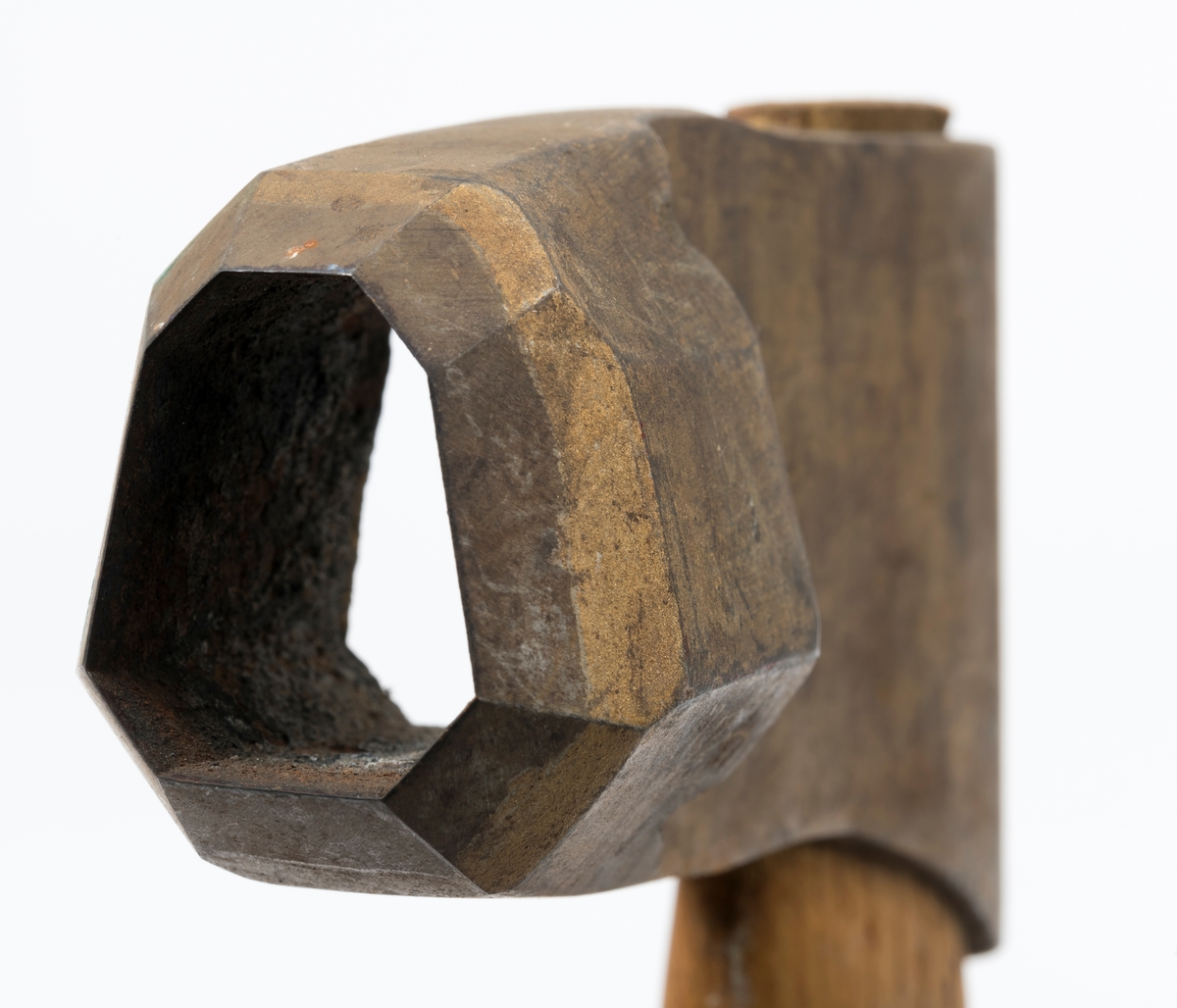 Øks - brukt til merking av fløtingstømmer i målings- og annammingsprosessen som foregikk langs vassdragene i overgangsfasen mellom vinter og vår, da tømmerstokkene etter måling formelt skiftet eier - fra skogeieren som hadde organisert hogst og framkjøring til sagbruk eller treforedlingsbedrift, som kjøpte tømmeret med sikte på videre bearbeiding til produkter som var salgbare på et større marked. 

Øksehodet (den smidde delen) er 13,1 centimeter høyt fra eggpartiet til nakken. Nakkedelen er 8,2 centimeter lang og om lag 2,5 centimeter bred bakerst, 2,2 centimeter i fronten. «Kjakene» - sideveggene rundt «øyet» (skafthullet) – smalner fra nakkepartiet mot den nedre delen av bladet. På den nedre delen av øksebladet er det en U-formet utsparing, og til endestavene (Knudsen-smedene kalte dem «stabler») er det påsveiset en cirka 3,8 centimeter høy fasslipt, profilegget «sko». Eggprofilen er en noe avlang åttekant (oktogon). Dette symbolet ble altså slått inn i yteveden på fløtingstømmeret, som tegn på hvem som eide stokkene. Øksehodet er, med unntak av den fasslipte eggen, lakkert med gulfarget lakk. Denne øksa har ikke noe smedstempel, men form og overflatebehandling tyder på at den er produsert av smeden Karl Henrik Knudsen (1870-1956) i Mjøndalen i Nedre Eiker.

Denne øksa har et 61 centimeter langt og forholdsvis rett treskaft (sannsynligvis ask eller hickory). Som økseskaft flest er det bredest i høyderetningen og smalest i bredderetningen i den fremre enden, og mer rundovalt bakerst. Den fremre enden av skaftet er kilet med en trekile som skulle redusere faren for at øksa løsnet fra skaftet under merkingsarbeidet.

Ifølge «Merkekart 1953 for Glommen» (gjengitt i Julius Nygaards skogalmanakk for 1954) ble dette merket brukt av Fetsund lenser i Glommavassdraget (jfr. merke nr. 35).

Litt generell informasjon om bruken av merkeøkser i skogbruket finnes under fanen «Opplysninger».