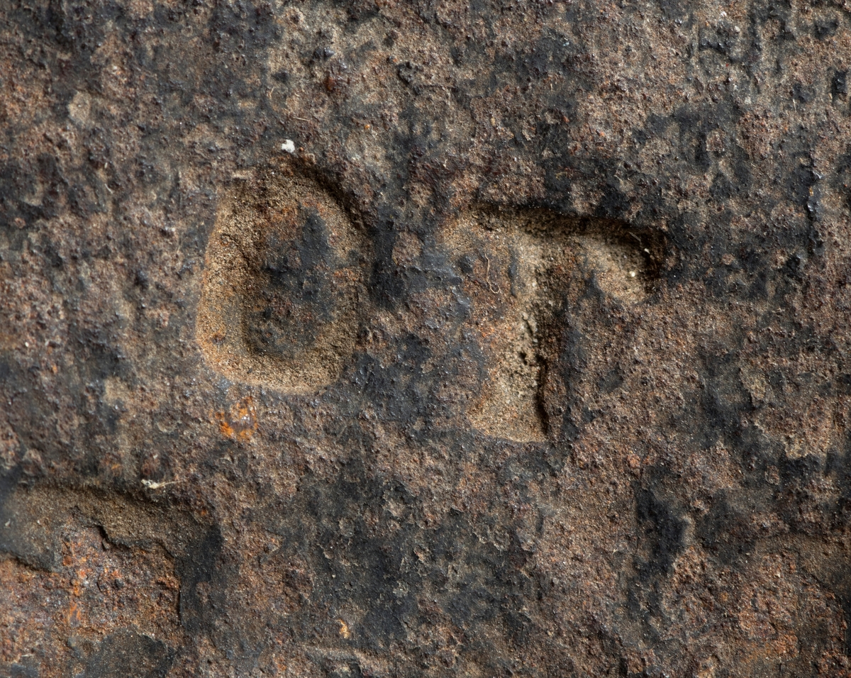 Øksehode – brukt til merking av fløtingstømmer i målings- og annammingsprosessen som foregikk langs vassdragene i overgangsfasen mellom vinter og vår, da tømmerstokkene etter måling formelt skiftet eier – fra skogeieren som hadde organisert hogst og framkjøring til sagbruk eller treforedlingsbedrift, som kjøpte tømmeret med sikte på videre bearbeiding til produkter som var salgbare på et større marked. 

Øksehodet (den smidde delen) er snaut 14,3 centimeter høyt fra eggpartiet til nakken. Nakkedelen er 9,0 centimeter lang og om lag 3,1 centimeter bred. «Kjakene» – sideveggene rundt «øyet» (skafthullet) – smalner mot den nedre delen av bladet. Det er en sprekk i godset i underkant av øyet. Nederst på bladet er det utsmidd en drøyt 3 centimeter høy fasslipt, profilegget «sko» (målet er tatt i ytterkant, der denne komponenten er smalest). Eggprofilen er formet som omrisset av en fugl med utspente vinger. Dette symbolet ble altså slått inn i yteveden på fløtingstømmeret, som tegn på hvem som eide stokkene. Øksehodet har ikke noe synlig smedstempel. Stålet er noe rustent. Bokstavene «OT» - antakelig smedens initialer - er antakelig smedens initialer.

Dette øksemerket ble ifølge merkekart for Glomma fra 1921 bruk til tømmer som ble innkjøpt på vegne av Lillestrøms Cellulosefabrik, en treforedlingsbedrift som var i virksomhet fra 1908 til 1943 (de første åra under navnet «Lillestrøm Sulfitfabrik»).

Litt generell informasjon om bruken av merkeøkser i skogbruket finnes under fanen «Opplysninger».