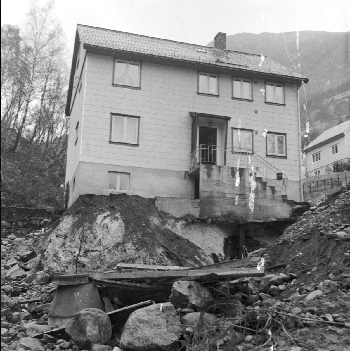 Bustadhus nesten undergravd av Sansarbekken som rann over i Tjoadalen.