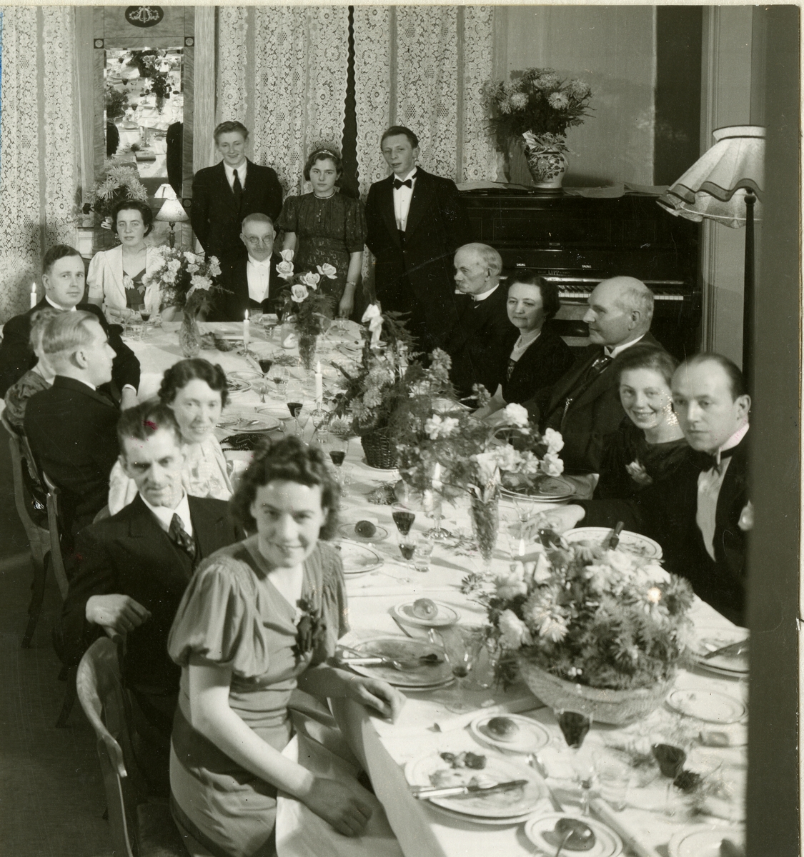 Fra familiealbum. 40- års jubileum den 8/12-1939 i Harmonien i Trondheim for Olaf T. Ranum A/S. Til venstre for bordet foran: Ingeborg Ranum, Hermod Pettersen, Gudrun Nustad Ranum, Bjørn Hammer, frøken Størdahl, Einar A. Dahle og frøken Johansen. Til høyre for bordet foran: G. Wettergreen, Agnes Ranum, herr Minsaas, Ragna Solberg, Nikolai Ranum og herr Sandvik. Stående bak fra venstre: S. M. Johansen, frøken Flatås og Einar Tønne.