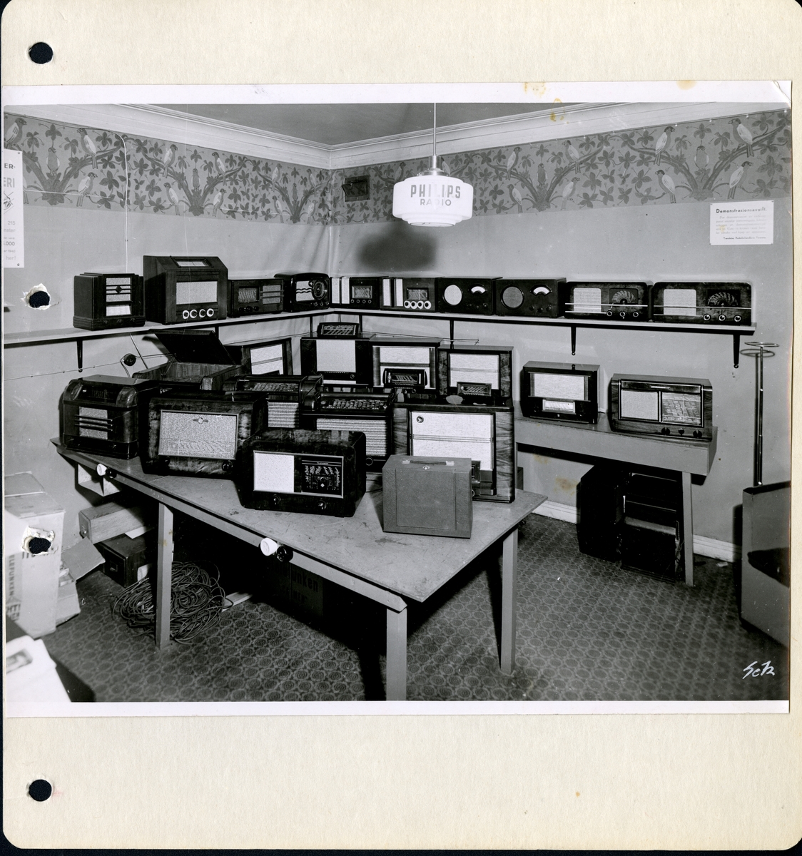 Fra familiealbum. Fotografi av radioavdelingen hos Olaf T. Ranum A/S. På taklampen over bordet står det Philips radio.