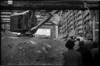 Grävmaskin och personal från Stockholms stadsbyggnadskontor i tunnel vid tunnelbanebygget i Stockholm 1946.