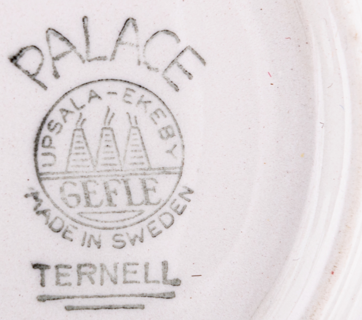 Kaffekopp med fat, modell BT i dekoren Palace, form och dekor av Berit Ternell. Svart stämpeldekor med gult band.