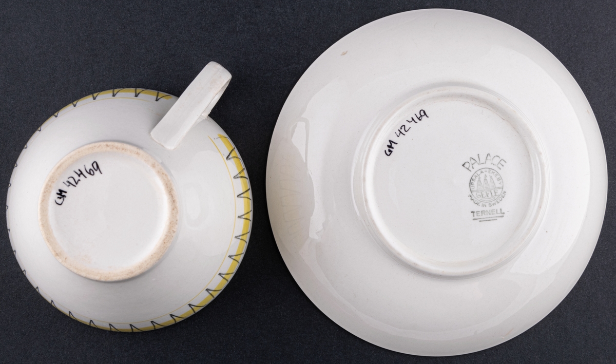 Kaffekopp med fat, modell BT i dekoren Palace, form och dekor av Berit Ternell. Svart stämpeldekor med gult band.