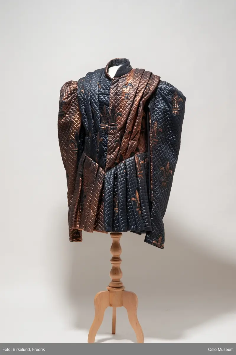 A= Bronse/ blåsvart boblestoff.
B= svart hatt med rosa fjær.