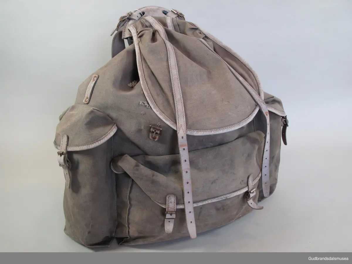Ryggsekk antakelig fra fra 1930-tallet. Likhetstrekk med  Bergans Original Sverre Young og Peer Gynt sekker fra samme periode. Meis i metall. Bred lomme med lokk, lærreimer og metallspenner på front. To sidelommer. Lokkreimer av lær og metallspenner på lær sydd/nittet på sekken. Hoderom med snørelukning i malje og lokk med lærreimer og metallspenner. Ryggreimer i lær. Korsryggstøtte i kraftig stoff, boltet til meisendene. Lerretsforsterkning på sekk bak nedre meisrør. Alle lokk er kantet med lærforsterkninger. Lærholder rundt toppen av meisen med fester for ryggreimer.