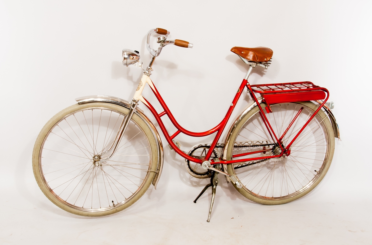 Damcykel Columbus. Tillbehörsfack under pakethållaren, med pump och verktygssats i låda av unicamaterial. Cykellykta av märke Philips. Dekal märkt "Europeiska cykel importen Stockholm"