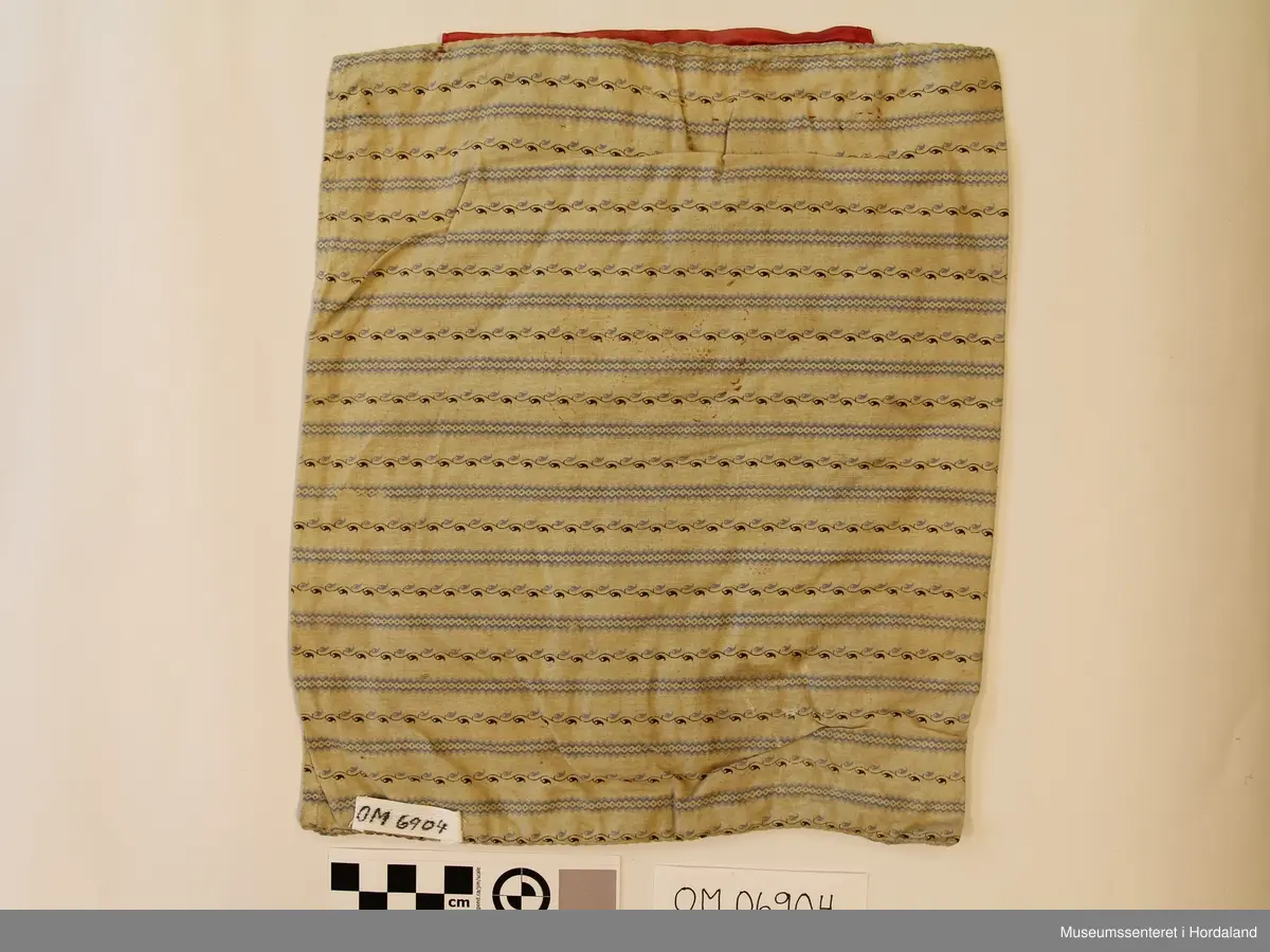 blomstermønster, gullband og rosasilkeband øvst.