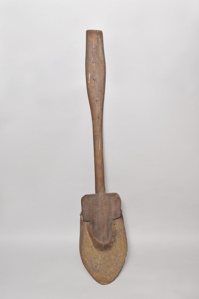 Spade, av barrträ med rundat järnskott blad, skaftet med handvalk, inskuret "A" samt bomärke.