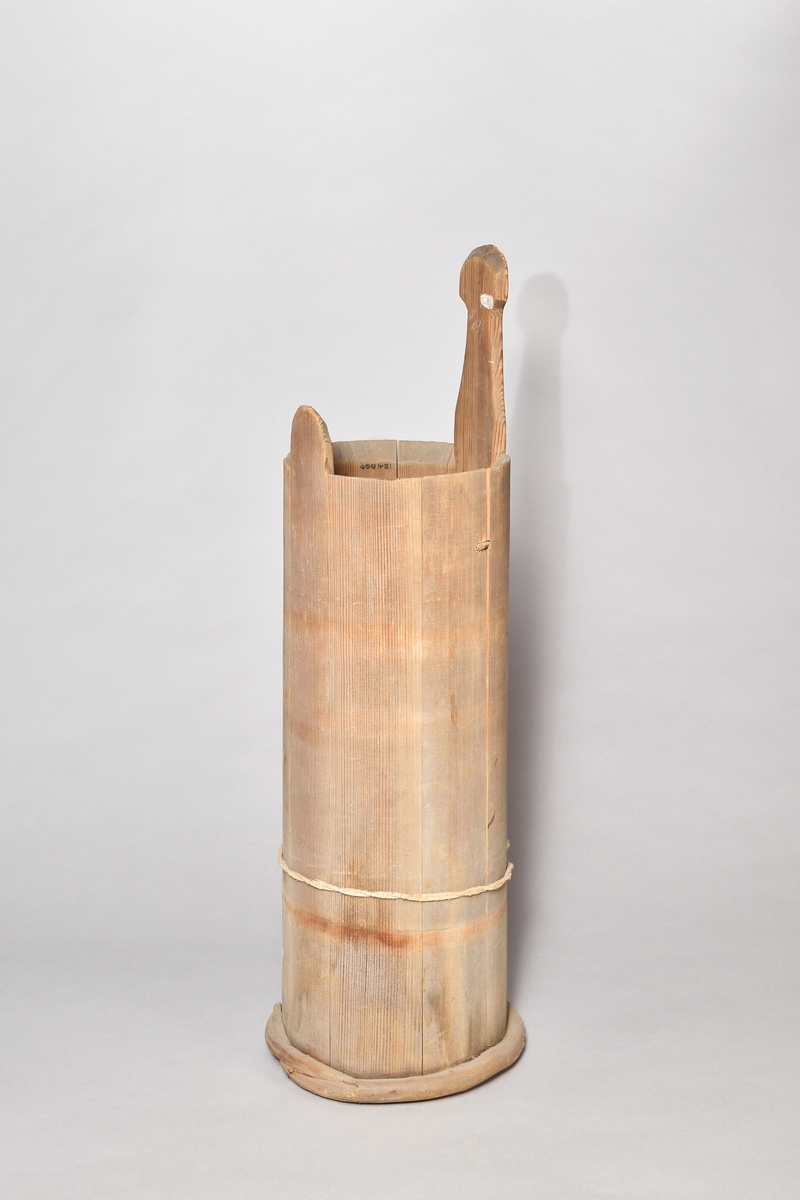 Ljuskärna, laggad av gran, omålad, cylindrisk. Två stavar förlängda, varav en utgör ett handtag, enkelt profilerat. Nio stavar, fyra vidjor, varav tre saknas. Lock saknas. Under botten ett svagt inristat B. Kan även ha använts som smörkärna.