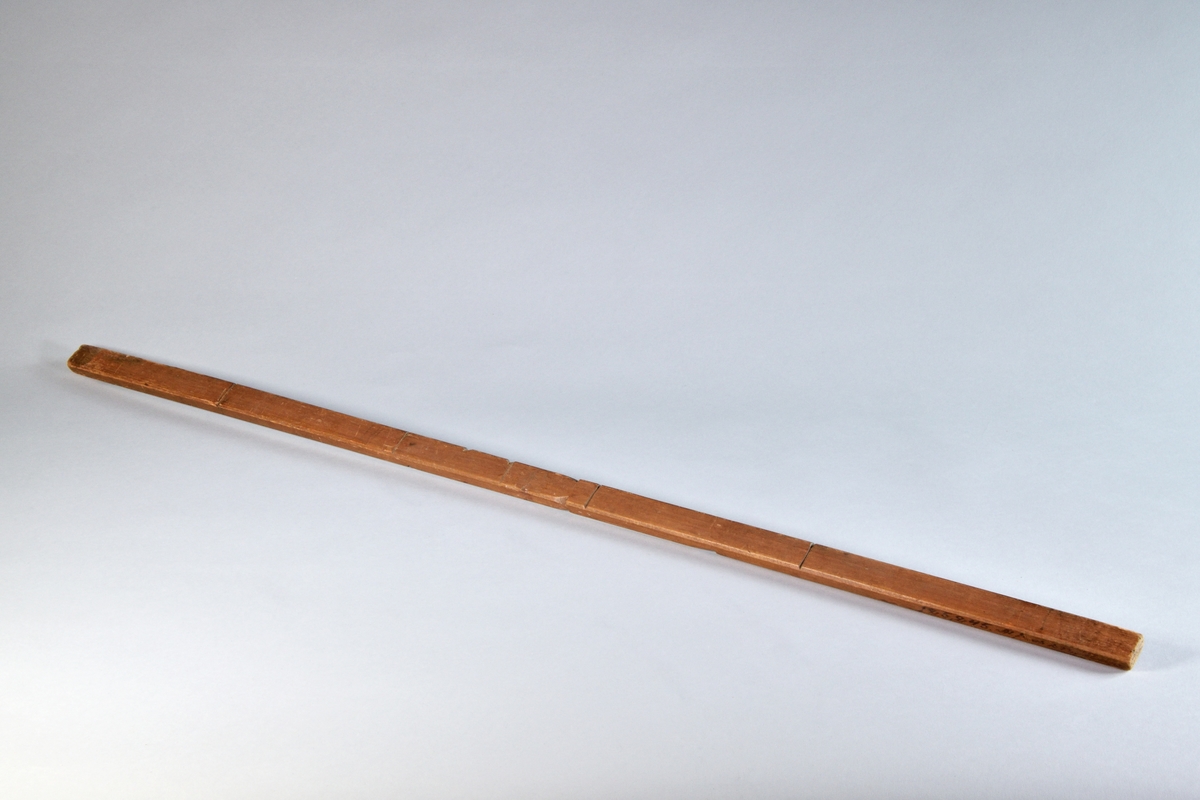Måttstock, alnmått (dock ej det vanliga alnmåttet). Av furu, med skåror med 14 eller 7 cm mellanrum och hak. I änden inskuren krysstjärna.