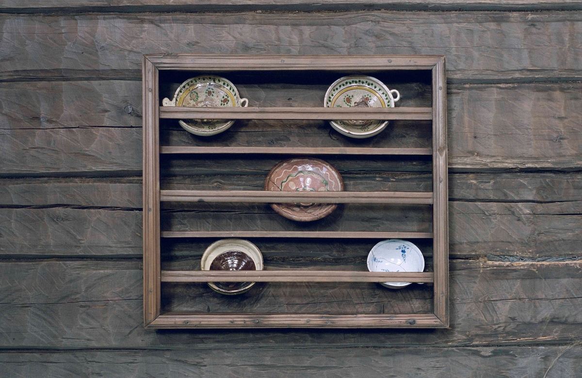 Hylla av omålat barrträ, rektangulär form, väggfast. Ram av brädlappar, randhyvlade kantlister och slåar, två hyllplan, hopsinkad.