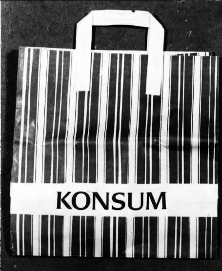 Påse av papper, vit med ränder i grönt och svart, svart text: KONSUM. Bärkasseföretaget Nissafors AB 25 år.