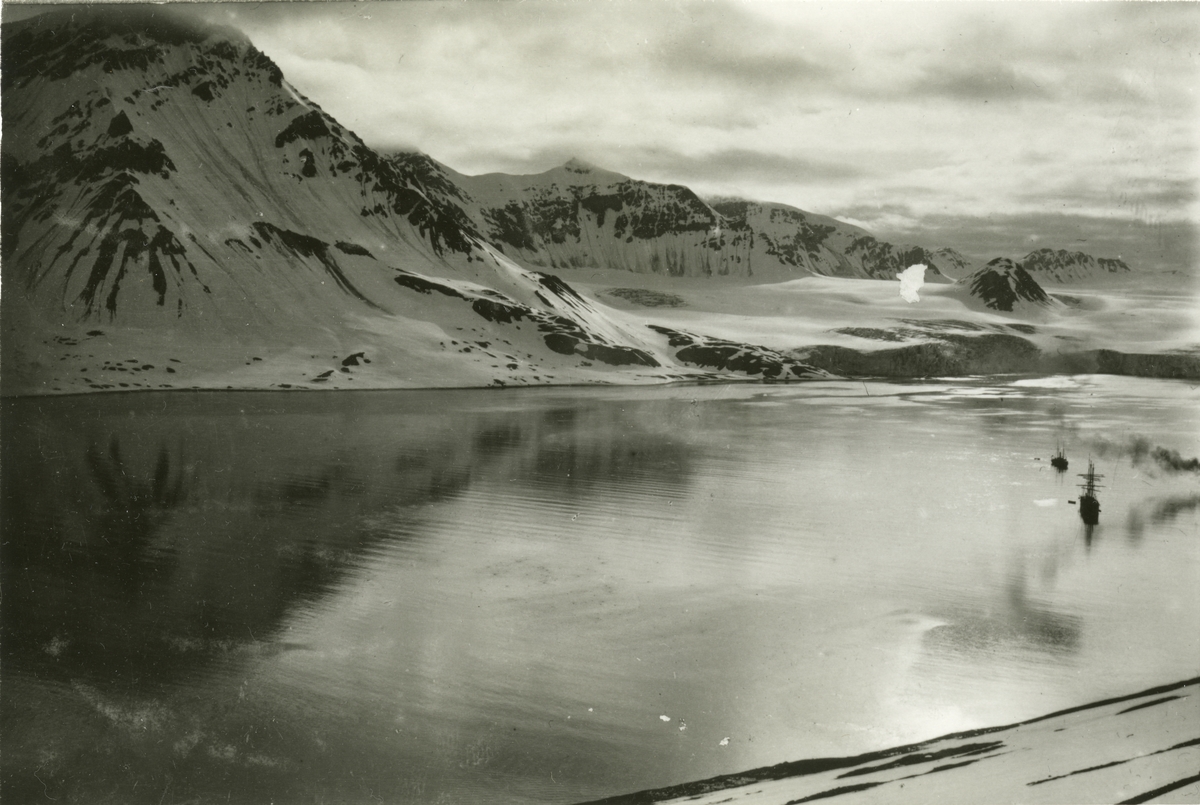 Bildtext: "Spetsbergen, Safe Bay"
Vy över Safe Bay fjord fotograferad från en bergssida. I fjorden syns två fartyg samt ångan från ett tredje. I bakgrunden syns en glaciär.