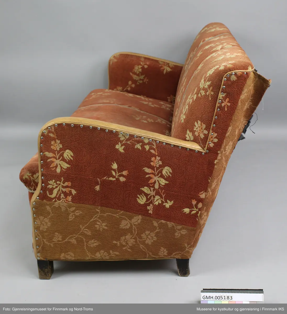 Sofaen er en treseter der rygg og setet er avgrenset med tvinnede pyntebånd i grått. Rygg, sete og armlener er polstret og trekt med et stoff som har rødbrun bunnfarge og et lysebrunt blomstermønster. Trekket er spikret til ramma på undersiden og på armlenen på utsiden. På kanten er armlenene trekt med lysebrun kunstskinn. På undersiden er sofaen lukket med plater, slik at polstringa ikke er tilgjengelig. Det er likevel synlig at sofaen består av en ramme med to tverrforbindelser. Dette er et inngrep som mest sannsynlig er gjort for å få støttet opp under sylinderfjærene. 