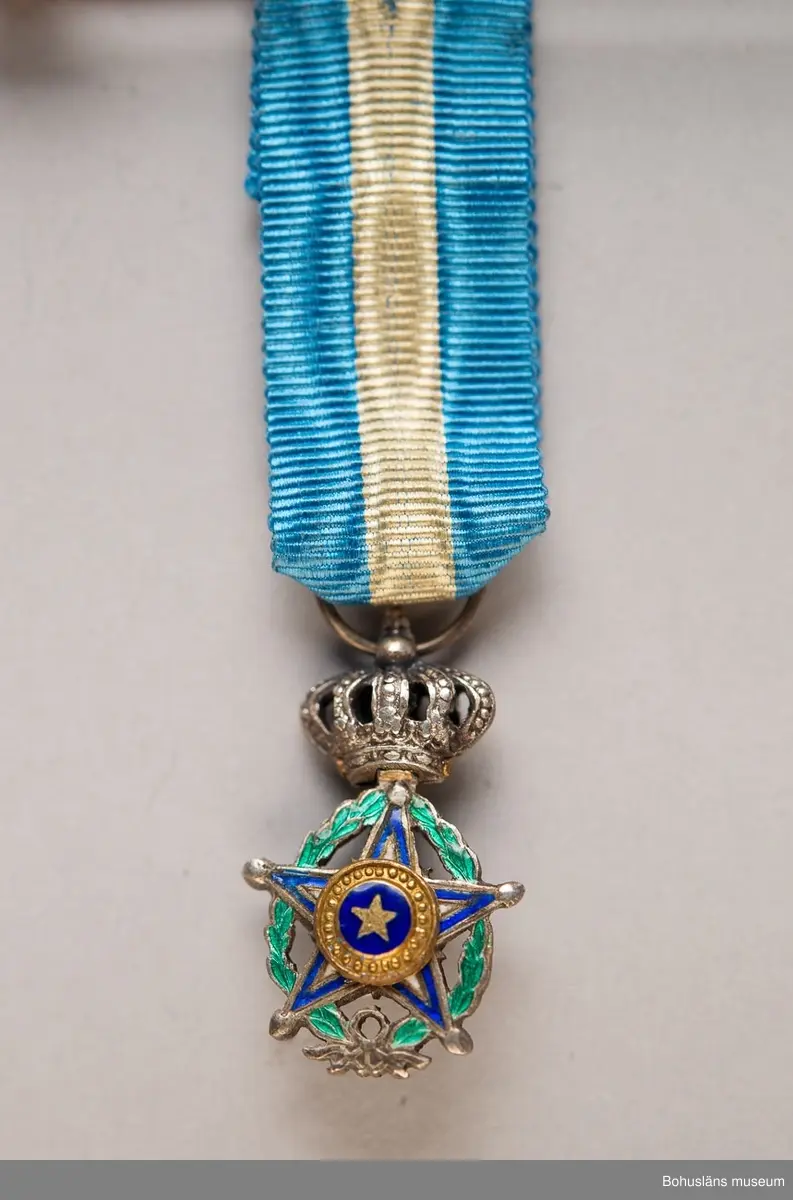 Tolv ordensminiatyrer fördelade och fastsydda på två nålar av guldfärgad metall.

Ur punktnummerkatalogen 1958-1976:
Kapten E. Göransson, Kungsbacka