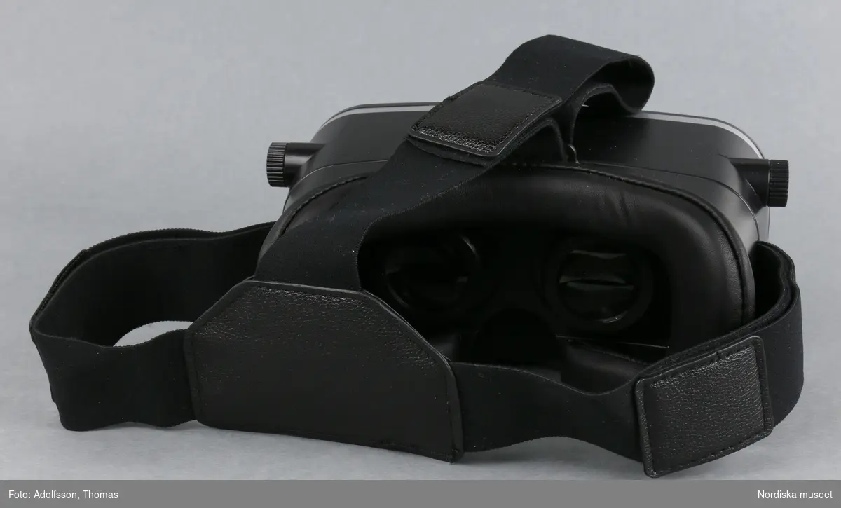 Virtuella glasögon (A-D)

A)Virtuella glasögon av plast. Cyklopformade, med remmar för att spänna fast vid huvudet. Avsedda att använda tillsammans med en smartphone (mobiltelefon), som placeras i ett fack framtill på glasögonen. För ungdomar eller vuxna från 13 år och uppåt. För att få en virtuell upplevelse krävs först att man laddar ned en applikation på internet www.trust.com/virutalreality. Två bilder framträder då framför vardera ögat. När man tittar genom glasögonens båda linser ger bilderna tillsammans en tredimensionell upplevelse av spel, filmer och video. Man får en känsla av att befinna sig i en annan värld. På sidorna av glasögonen finns två vred för inställning av skärpan. B) Säkerhetsföreskrifter C-D)bruksanvisning 

Kartong (332.989 a-b) och torkduk (332.990) ingår i förvärvet.
/Karin Dern 2018-06-11