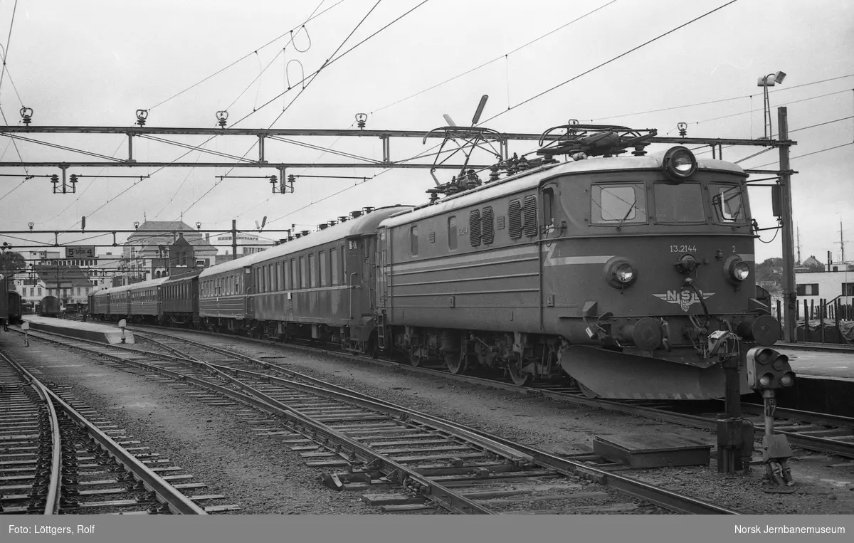 Elektrisk lokomotiv El 13 2144 med dagtoget fra Stavanger til Oslo V, tog 702, på Kristiansand stasjon. Ekstra vogner kobles til toget