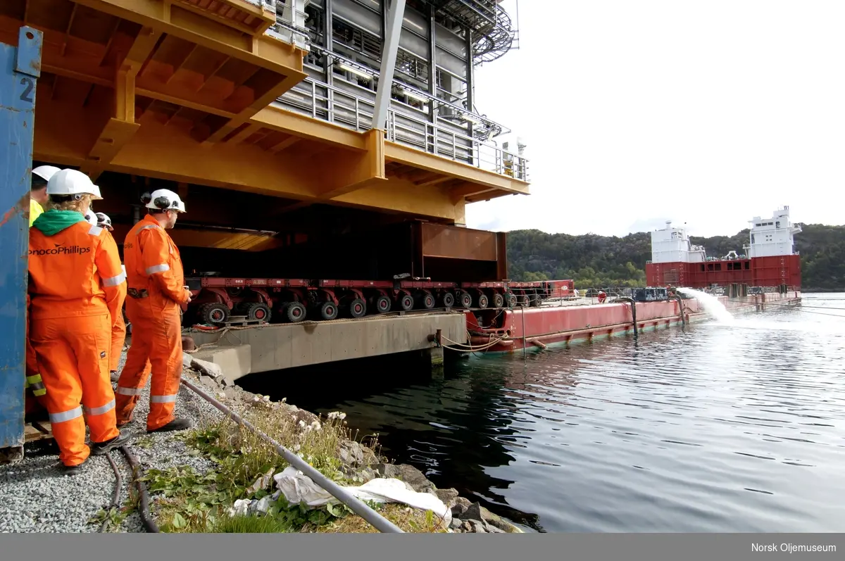 Ekofisk 2/4 M er bygget ved Aker Kværner Egersund., og er klar for opplasting på det nedsenkbare transportfartøyet Boabarge 20, som skal frakte dekket ut til feltet.  Overbygget flyttes på en kjempediger tralle med et utall av hjul mens den ruller over på fartøyet.  Det er store dimensjoner og mange hjul med under arbeidet.
Ballastvann pumpes ut av lekteren under prosessen.