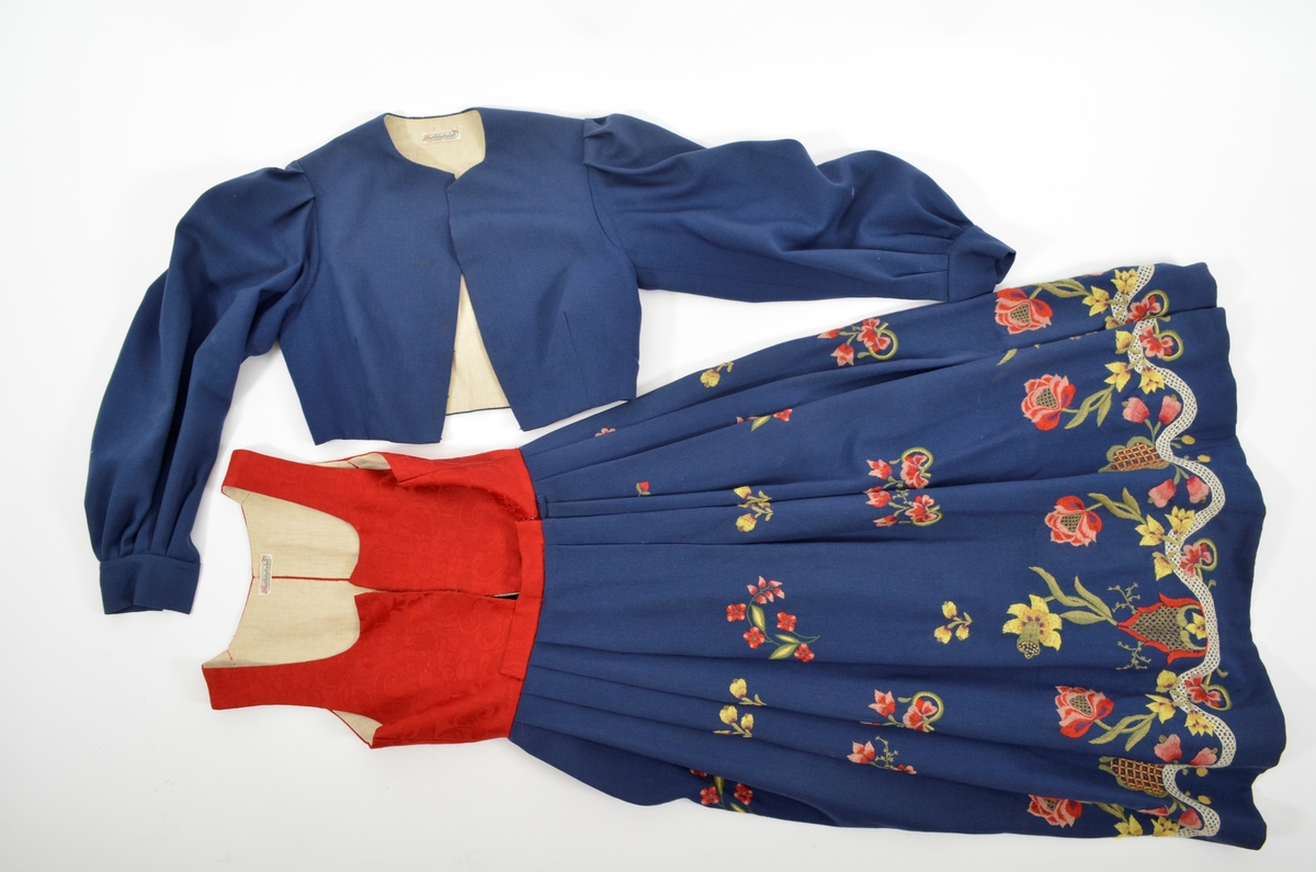 Grafferbunad med raudt damaskvove ulltøy i livet, og blått toskaftvove ulltøy i stakken. A. Livet har opning framme festa saman med tre hekter og krokar. Saum midt bak, og med to svinga ryggsaumar. Fóra med ubleikt halvlin.
Stakk i toskaft-vove ulltøy, brodert med ullgarn i forskjellige fargar. Rosemotiv. Den er foldelagt. Brei skonnering av svart bomulltøy i  nedrekanten.
B. Jakke i blått toskaftvove ulltøy. Opning midt framme med tre hekter og krokar til lukking. Eit snitt på kvar side. Erme er foldelagt oppå skuldera og nede ved ermekragen. 
C. Lue, pullue, i same tøy og broderi som stakken. Fóra med ubleikt halvlin. I nedrekant av pullen løpegang med rynka strikk. 
D. Lomme i same tøy og broderi som stakken. Sølvforgylt lommelås.