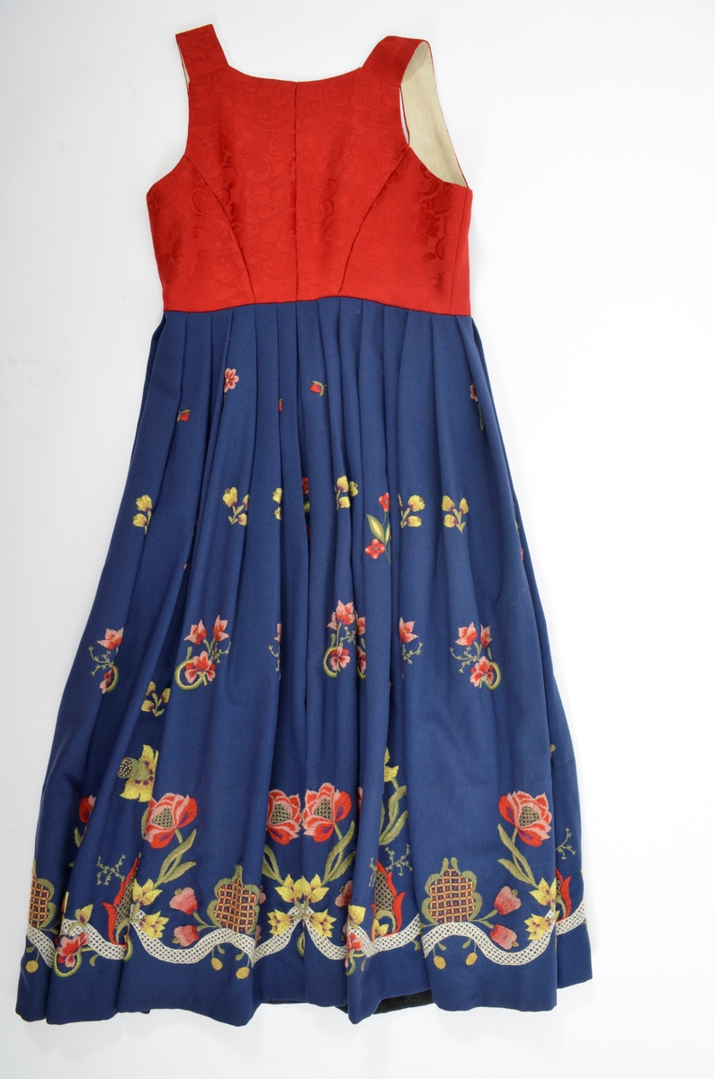 Grafferbunad med raudt damaskvove ulltøy i livet, og blått toskaftvove ulltøy i stakken. A. Livet har opning framme festa saman med tre hekter og krokar. Saum midt bak, og med to svinga ryggsaumar. Fóra med ubleikt halvlin.
Stakk i toskaft-vove ulltøy, brodert med ullgarn i forskjellige fargar. Rosemotiv. Den er foldelagt. Brei skonnering av svart bomulltøy i  nedrekanten.
B. Jakke i blått toskaftvove ulltøy. Opning midt framme med tre hekter og krokar til lukking. Eit snitt på kvar side. Erme er foldelagt oppå skuldera og nede ved ermekragen. 
C. Lue, pullue, i same tøy og broderi som stakken. Fóra med ubleikt halvlin. I nedrekant av pullen løpegang med rynka strikk. 
D. Lomme i same tøy og broderi som stakken. Sølvforgylt lommelås.