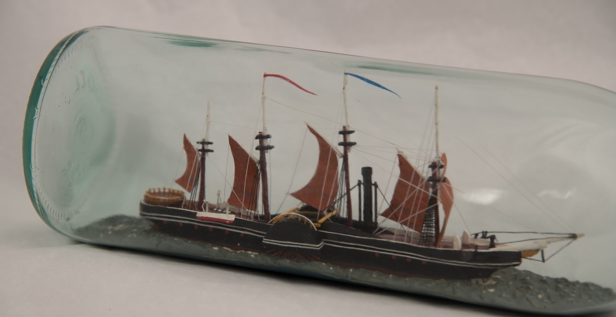 Flaskeskute: Hjuldamperen "Great Western".  Glass , klart , svakt grønnlig.  Knop rund munnningen , med rød lakk.  Sortmalt skrog, rødbrunt dekk og rødbrune seil , firemastet.  "Great Western"" var nr. 2 i den transatlantiske fart , Sirius var den første i 1838. "Great Western ," var konstruert av Isambard Kingdom Brunel , fikk 46 overfarter.