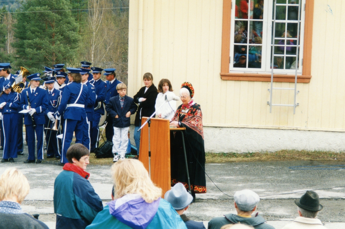 Gruppe,musikkkorps,bunad.
På talarstolen Gudrun Larsgard Bøthun.