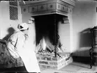 Kvinna sitter vid öppen spis, Östhammar, Uppland