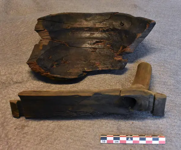 Lagget stav med innfellinger og utskåret tut vises her sammen med dreid trebolle.